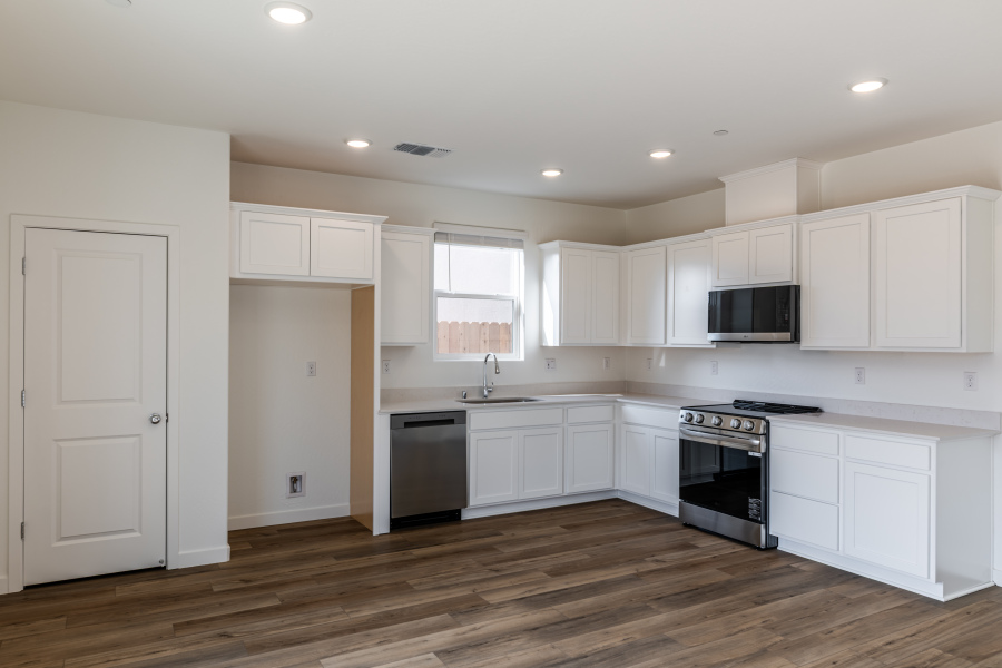 A kitchen with white cabinets.