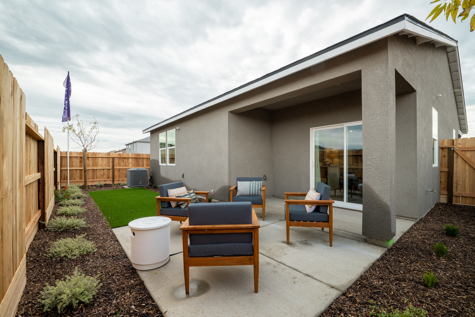 A patio with chairs and a table.