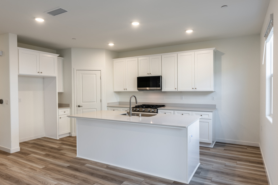 A kitchen with white cabinets.