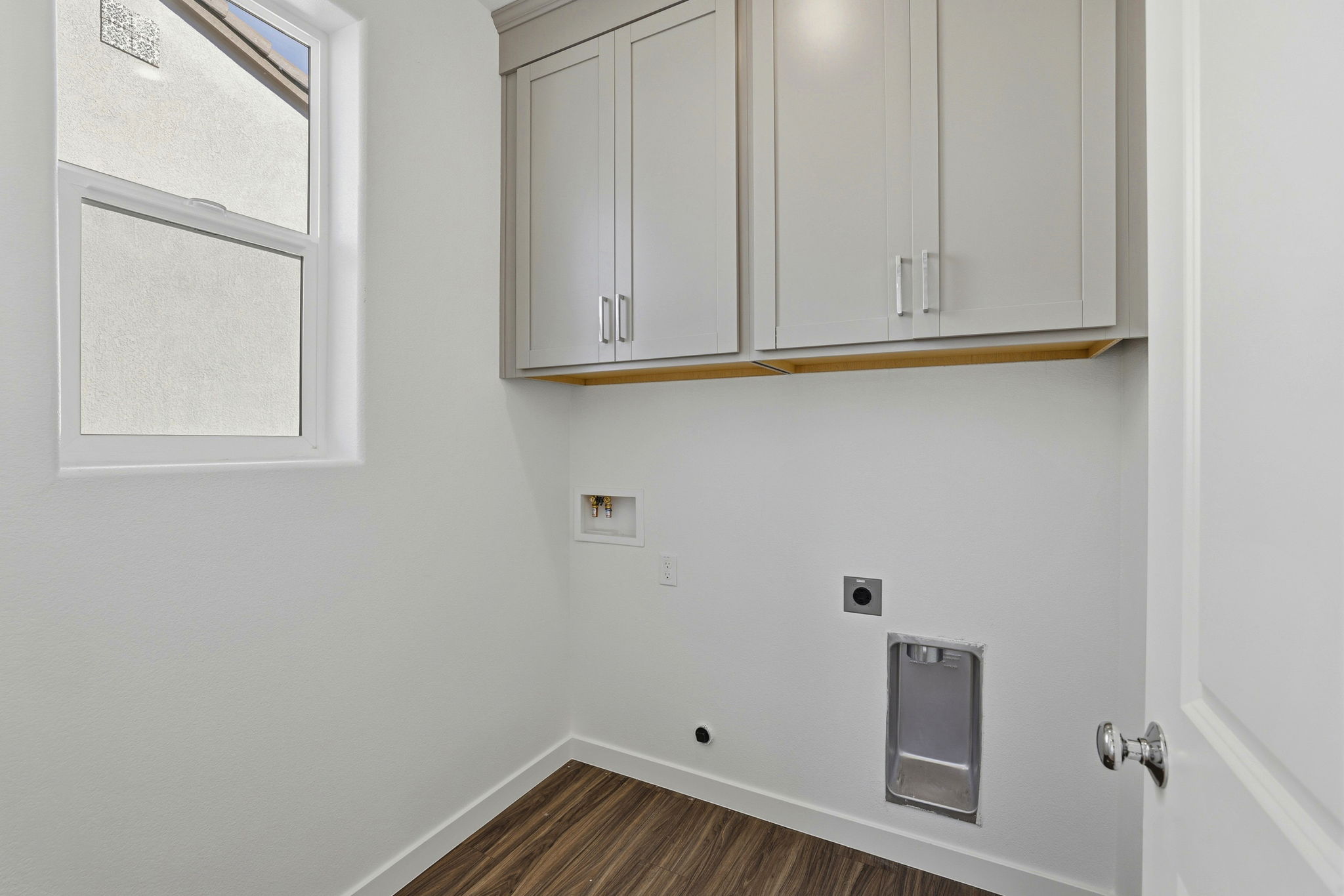 A white wall with white cabinets.