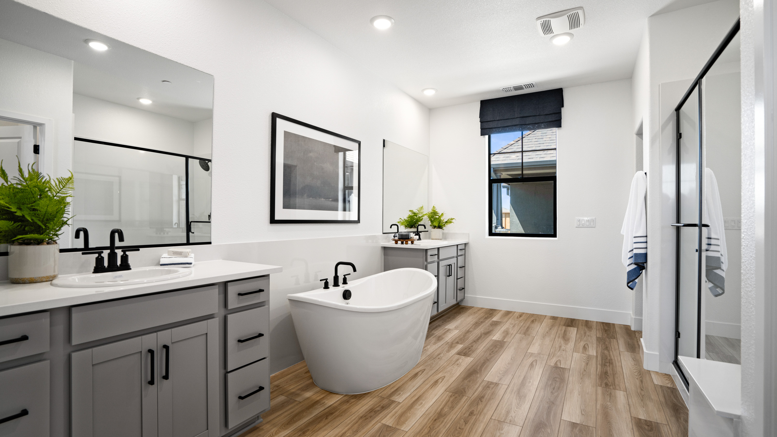 A bathroom with a tub sink and mirror.