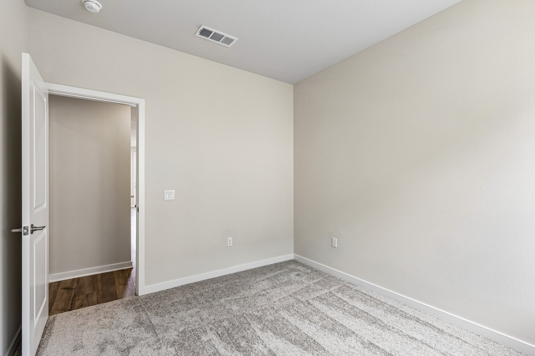 A room with a door and a carpet.