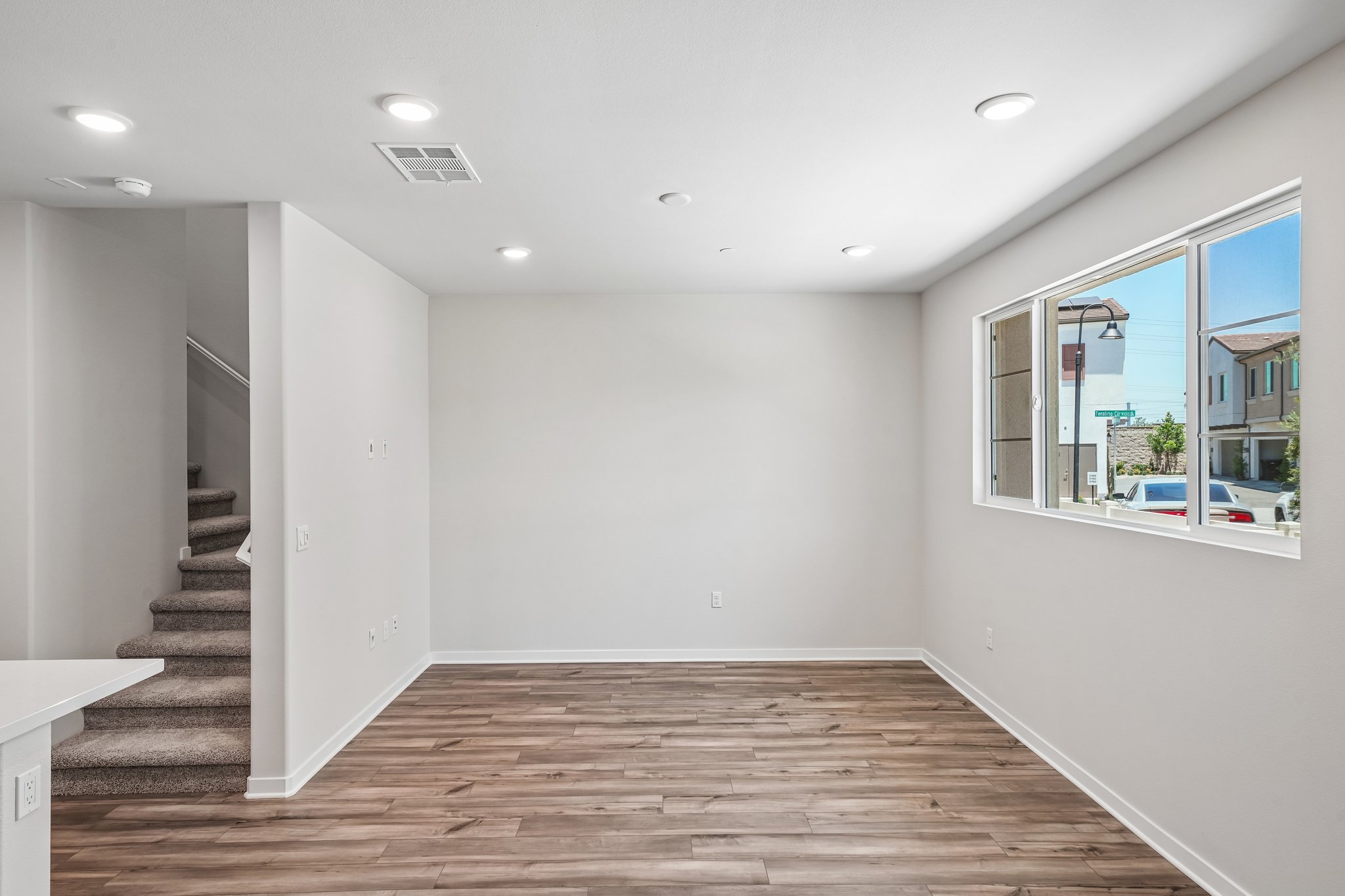 A room with a wood floor and a wood floor with a window.