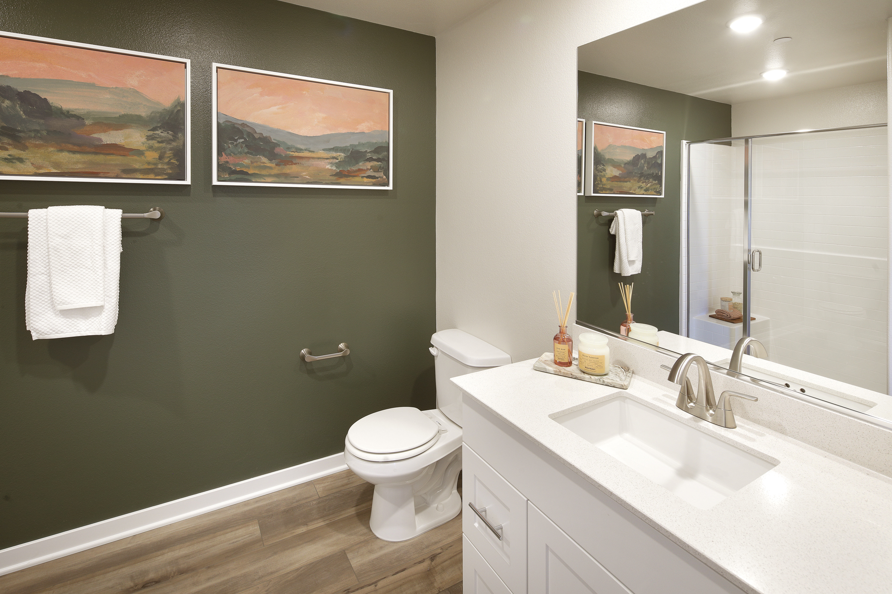 A bathroom with a sink toilet and a mirror.