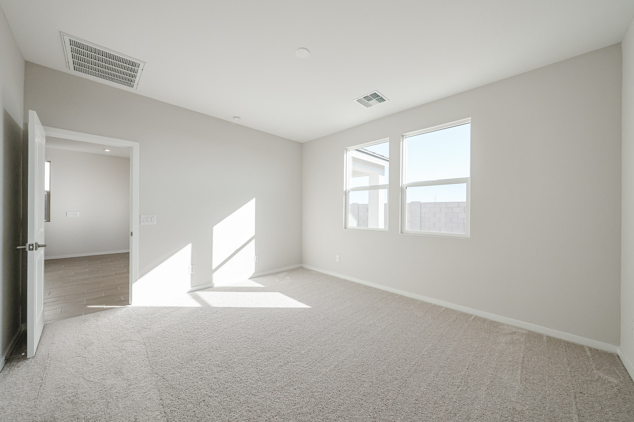 A room with a carpet and a door.