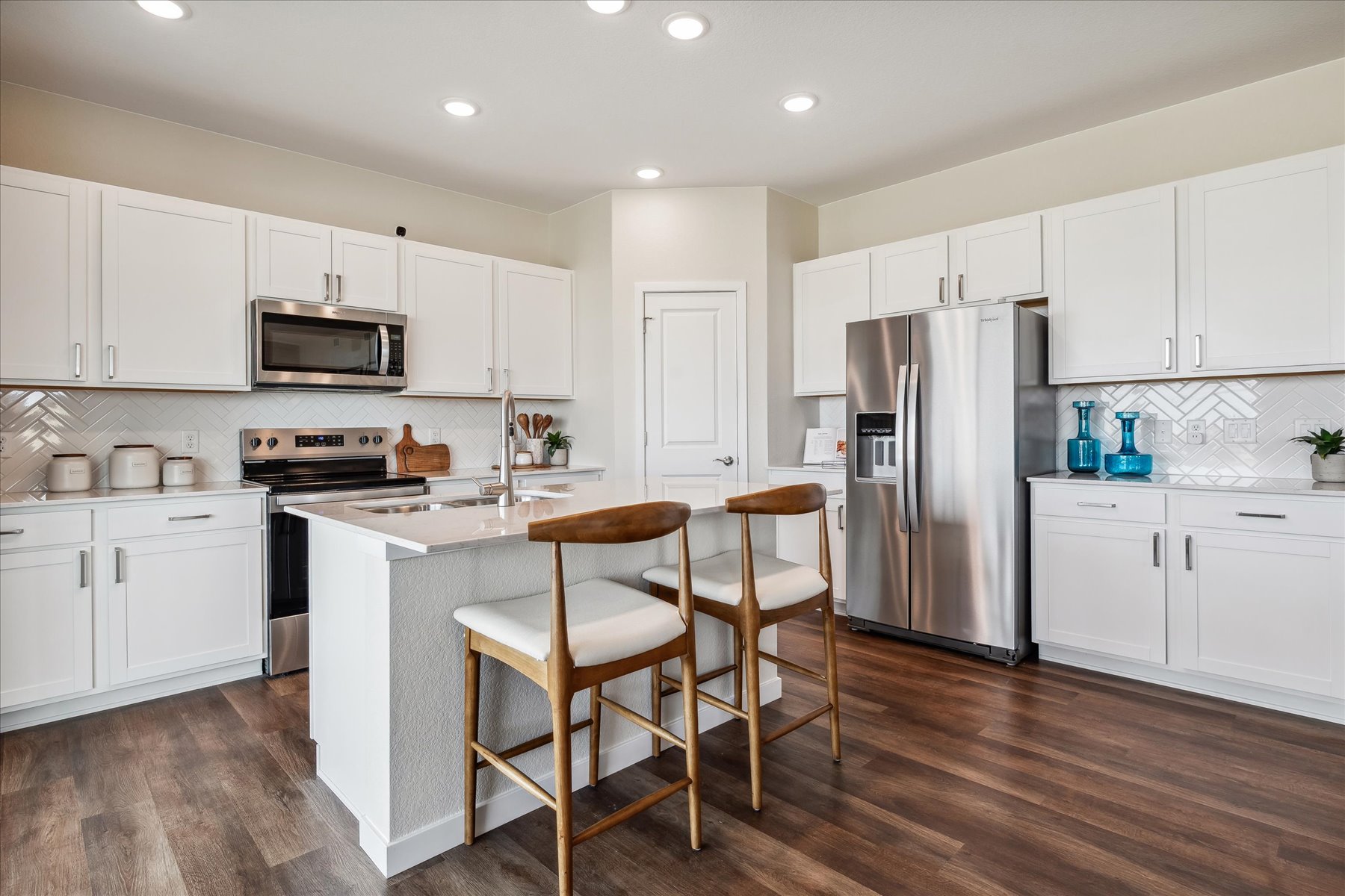 A kitchen with white cabinets.