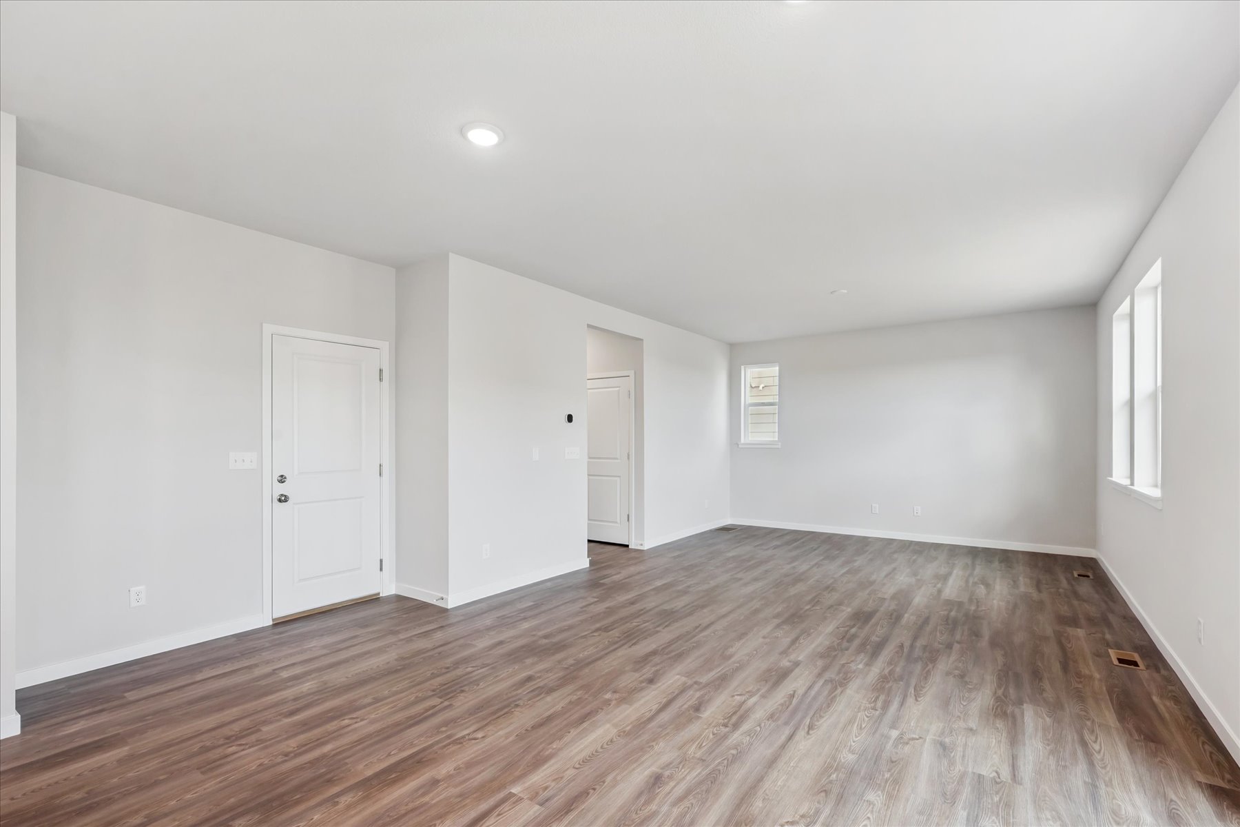 A room with a wood floor and white doors.