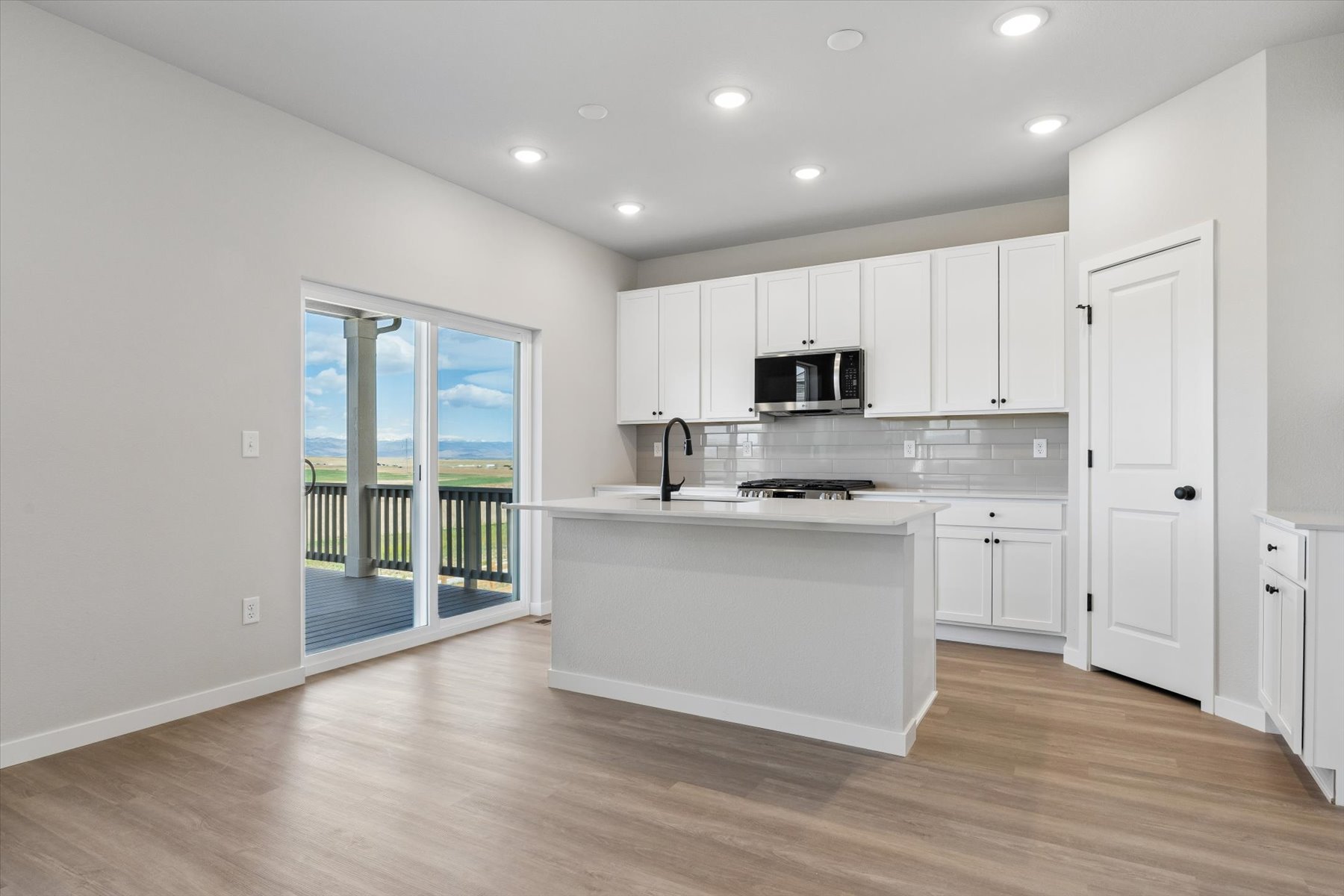 A kitchen with white cabinets.
