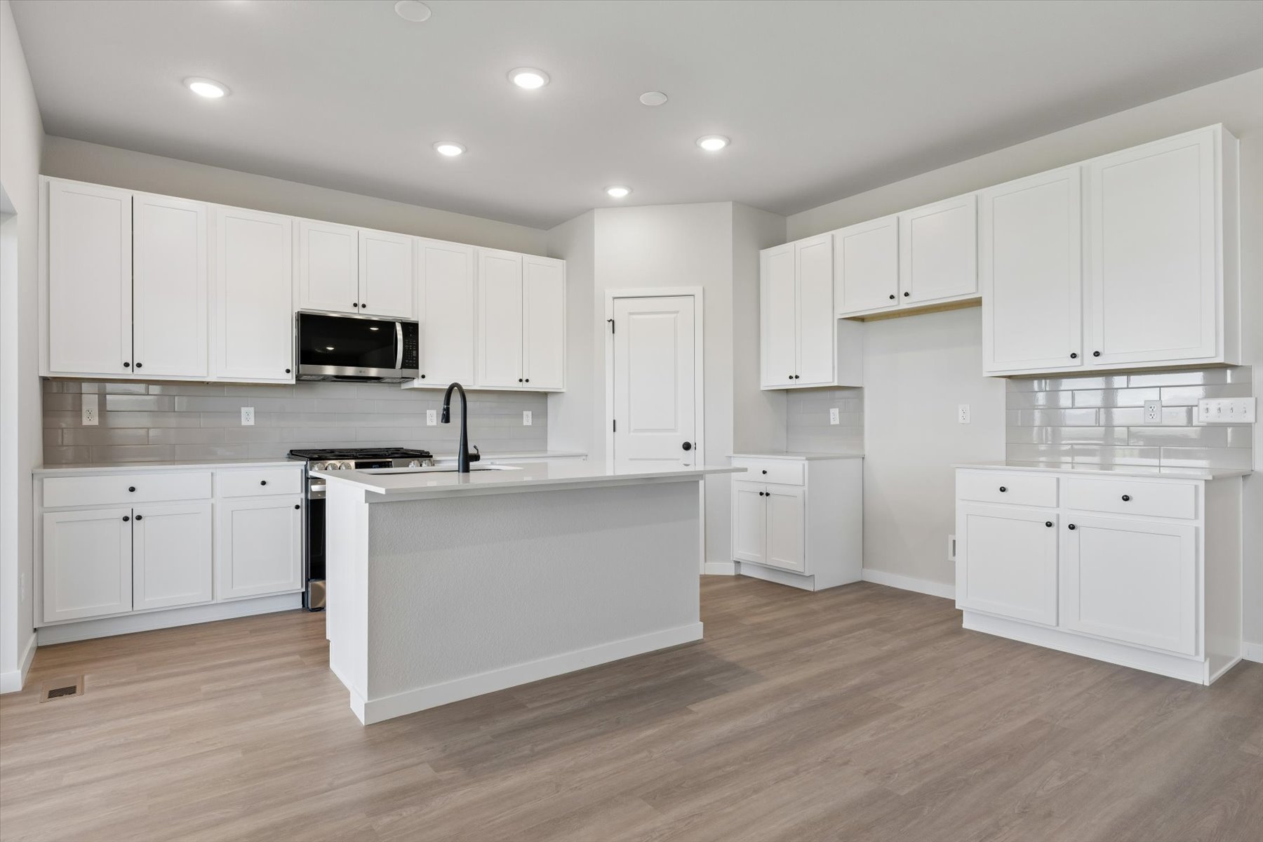 A kitchen with white cabinets.