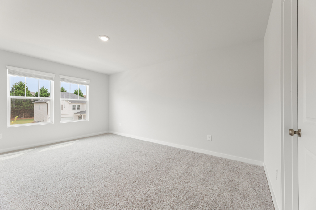 A room with a white wall and windows.