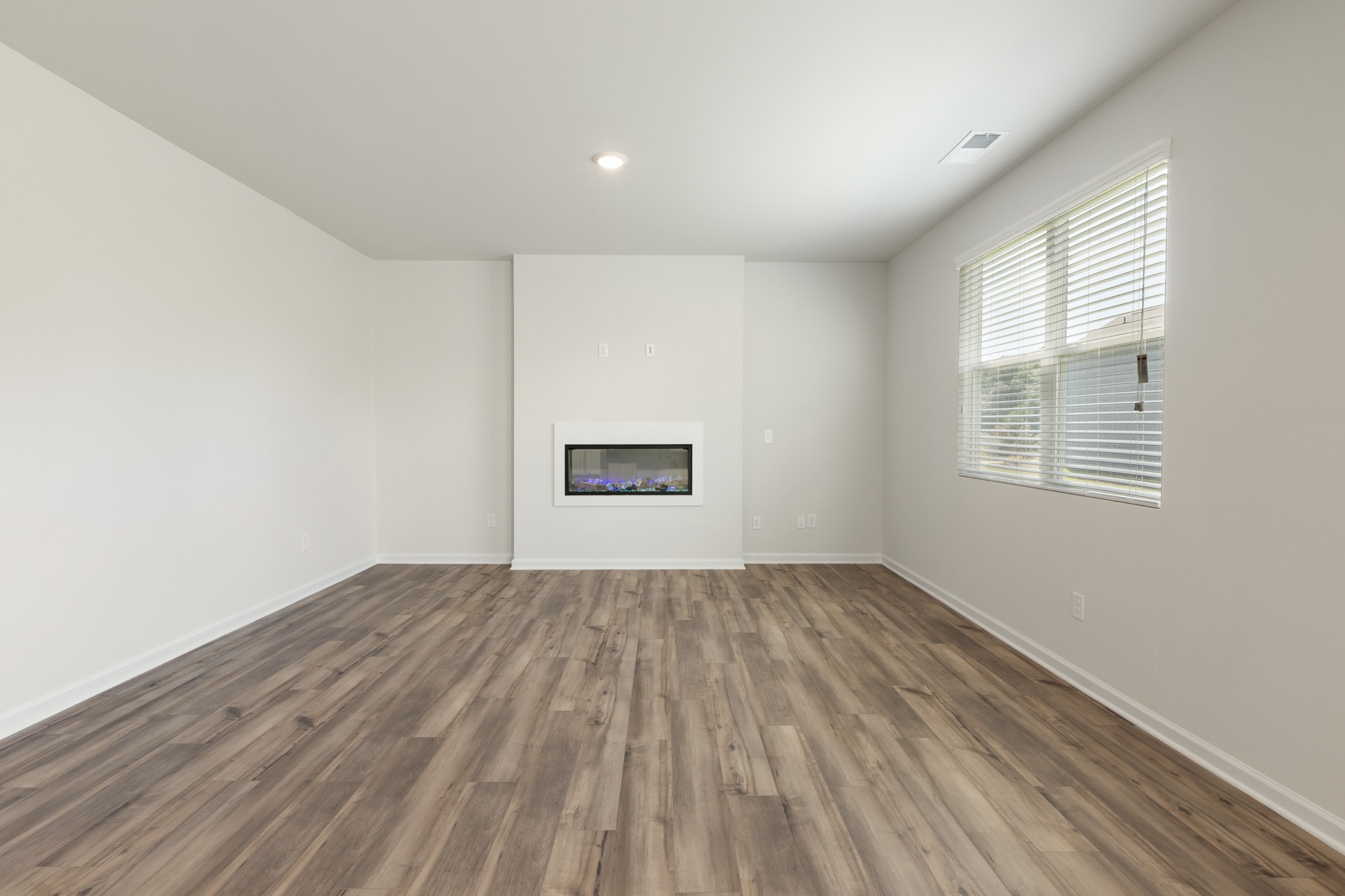 A room with a wood floor and a window.