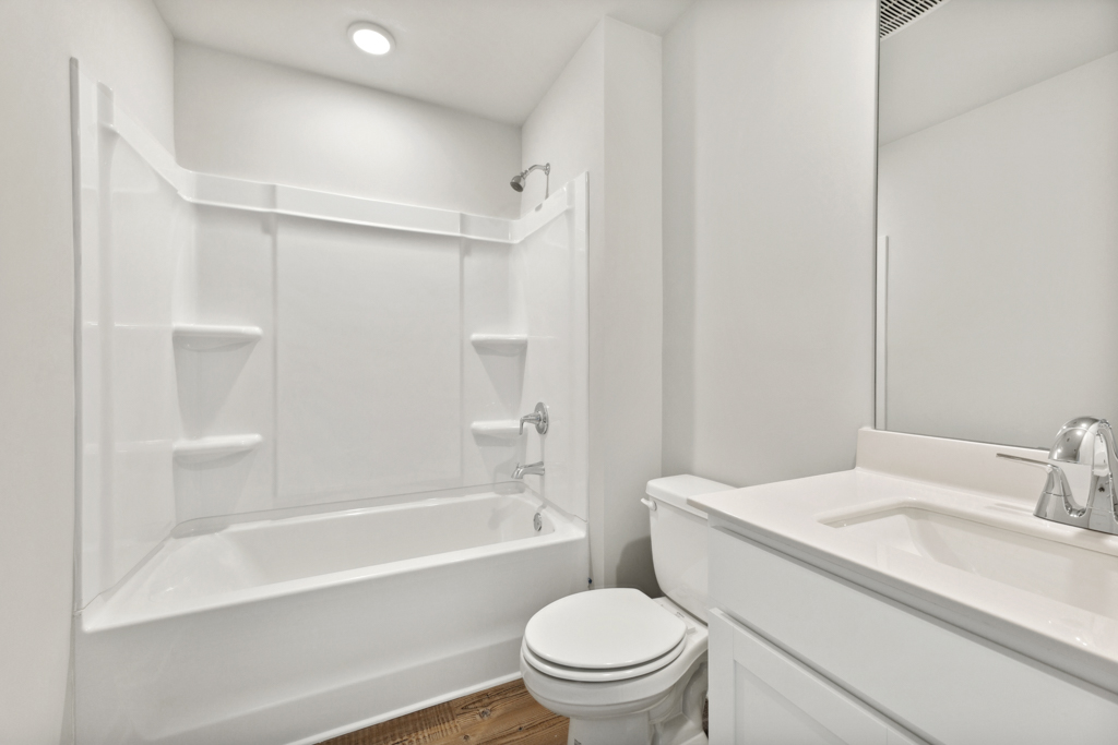 A bathroom with a tub toilet and sink.