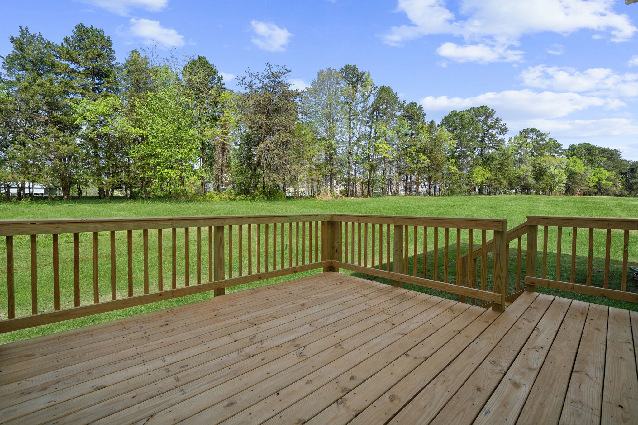 A wooden deck with trees in the background.