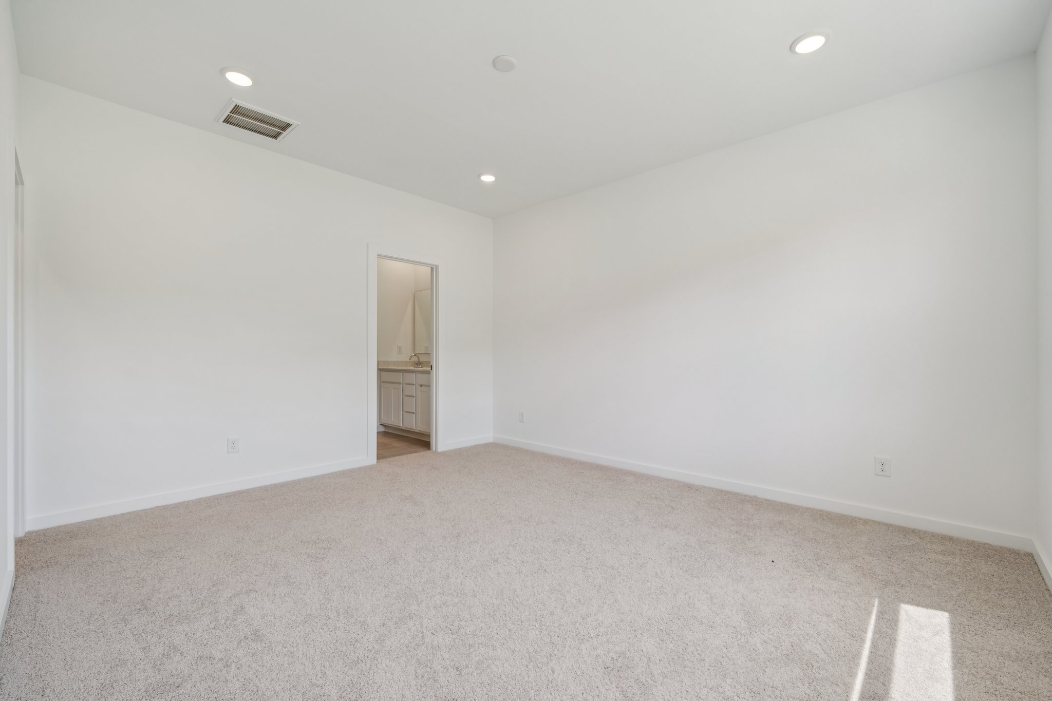 A room with a carpet and a door.