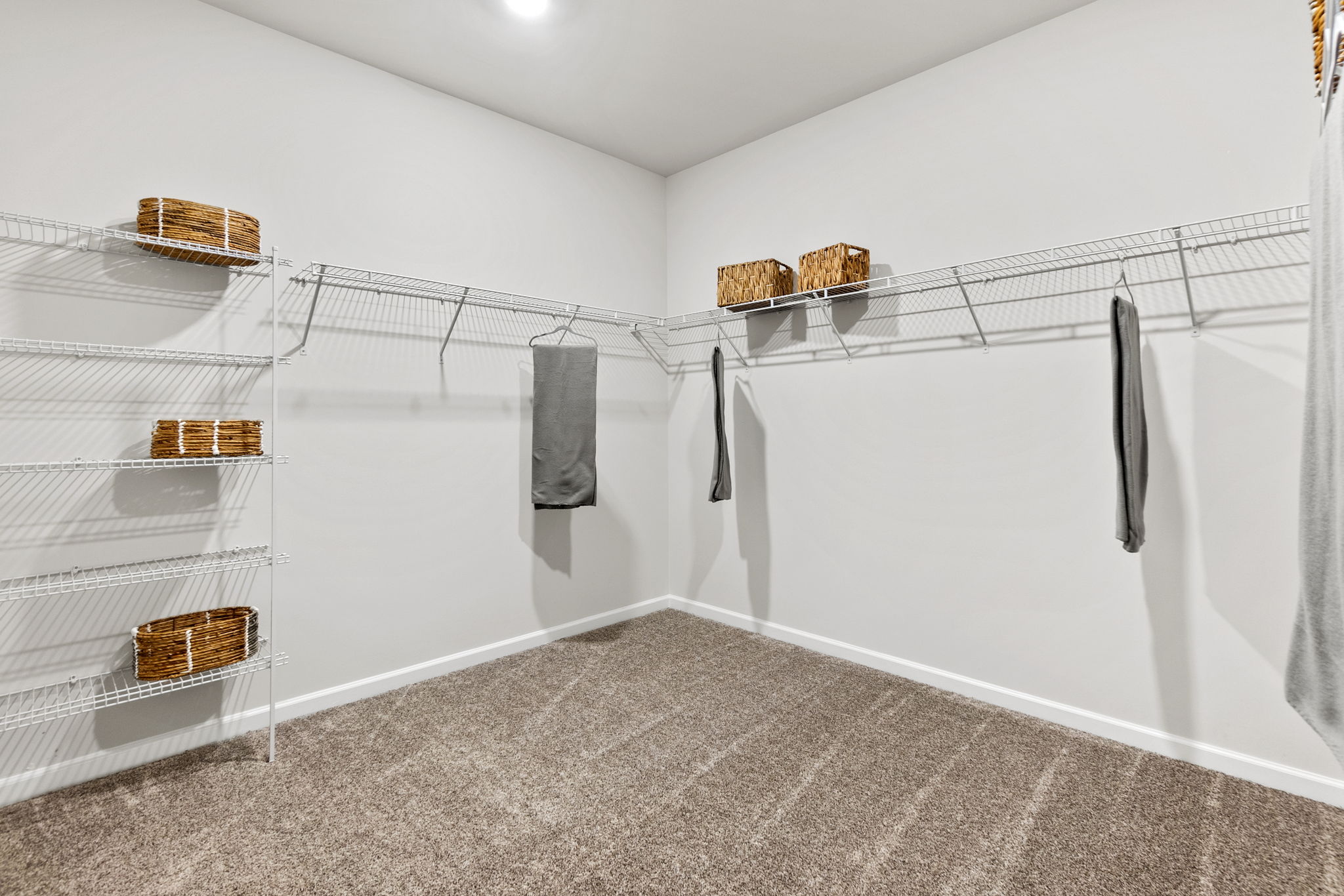 A white room with a white wall and a cage with a basket and a basket on it.