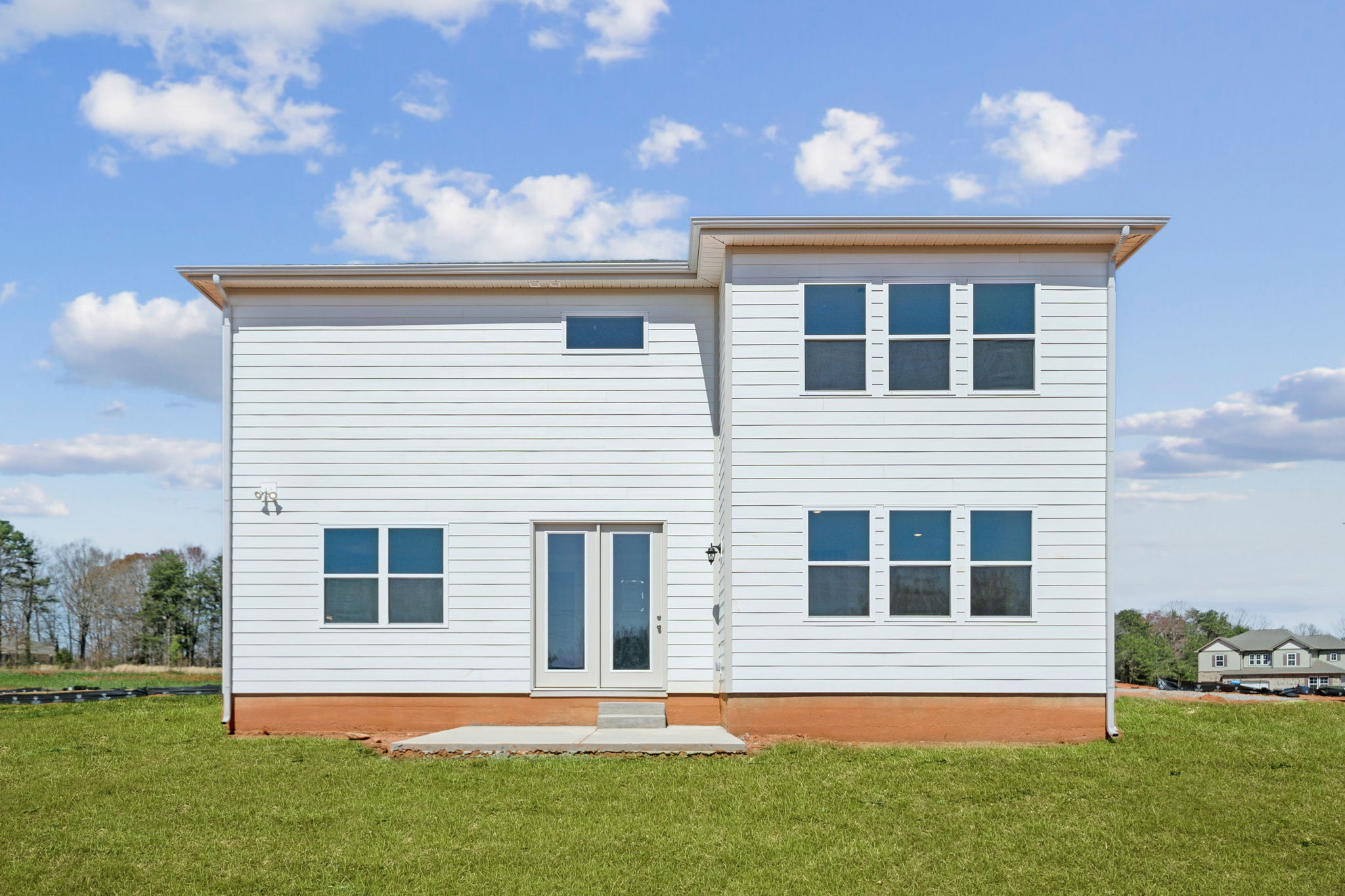 A white house with a grass yard.