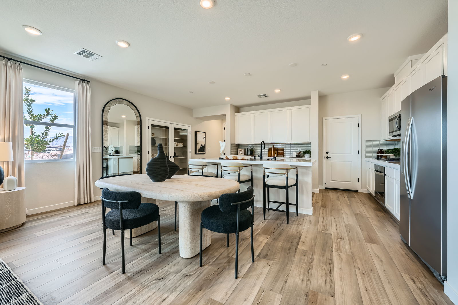 A kitchen with a dining table and chairs.