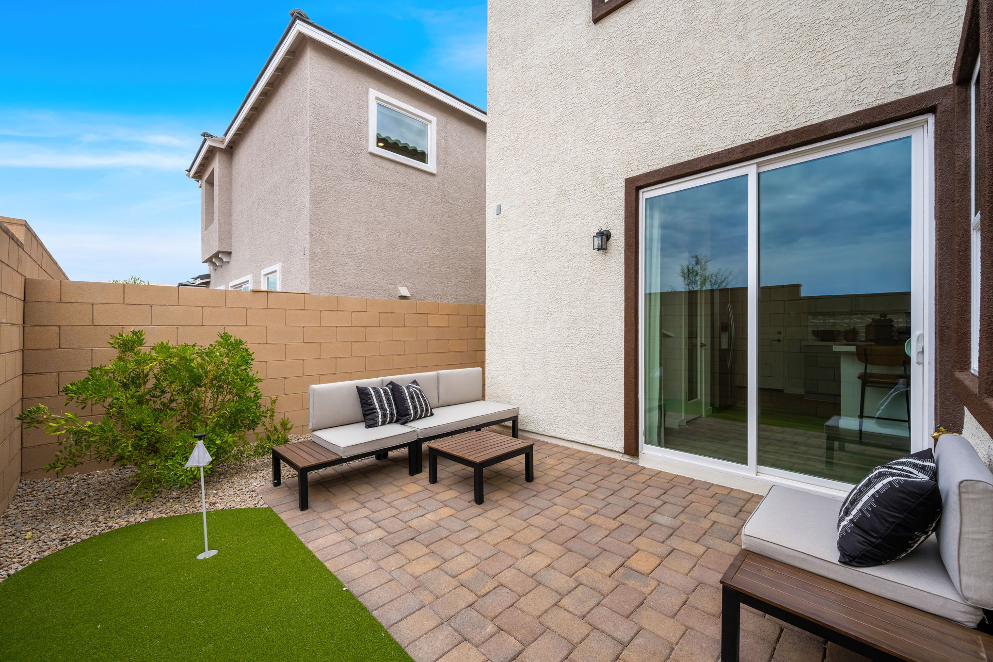 A patio with a bench and a pool.