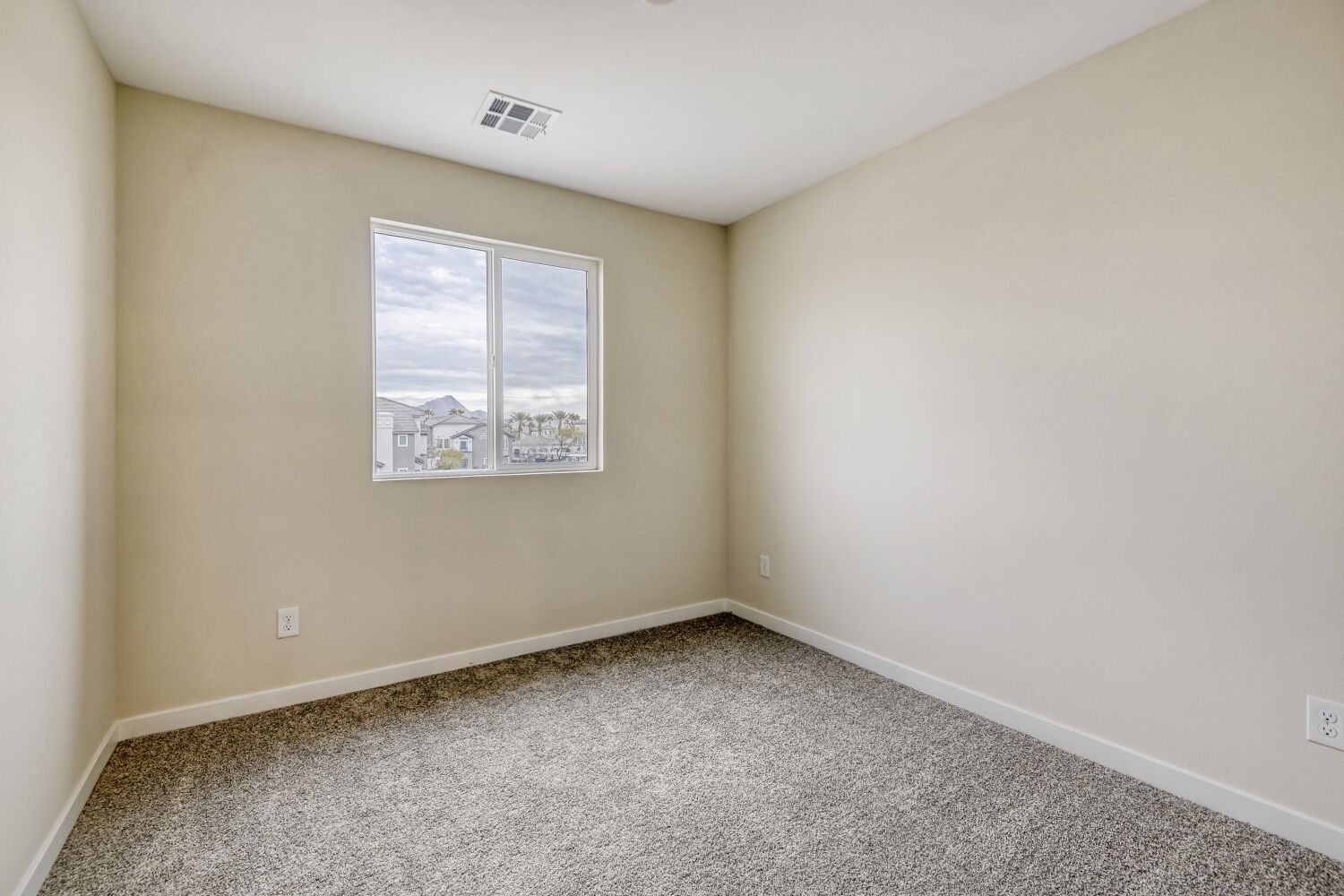 A room with a window and a carpet.