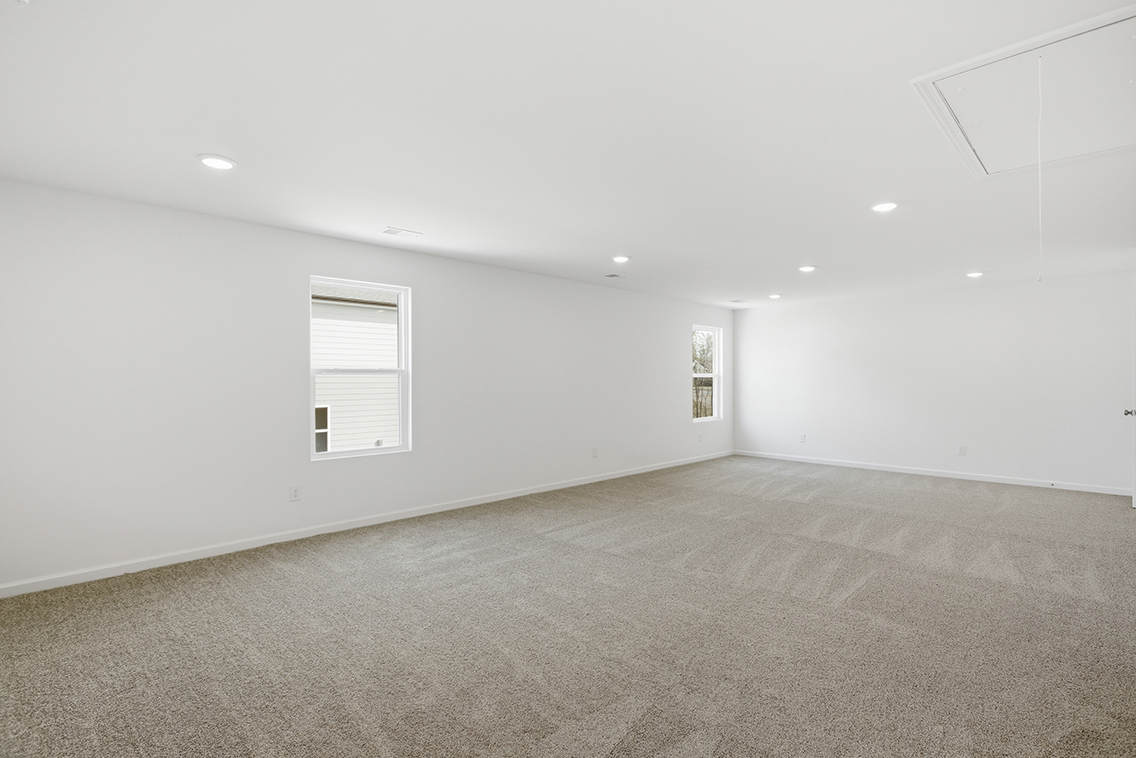 A room with a carpet and a window.