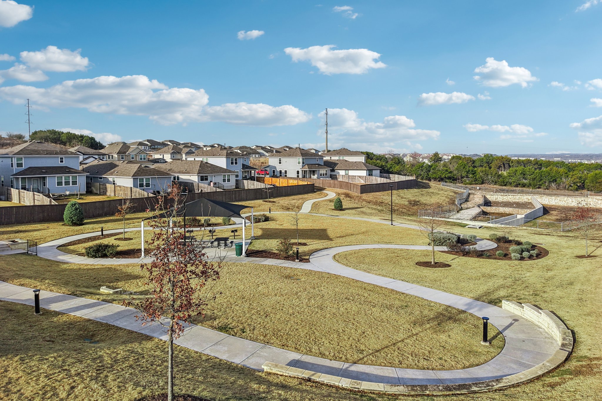 A large green field with buildings in the background.