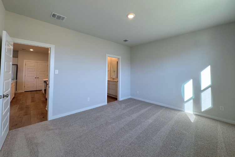 A room with a carpet and a door.