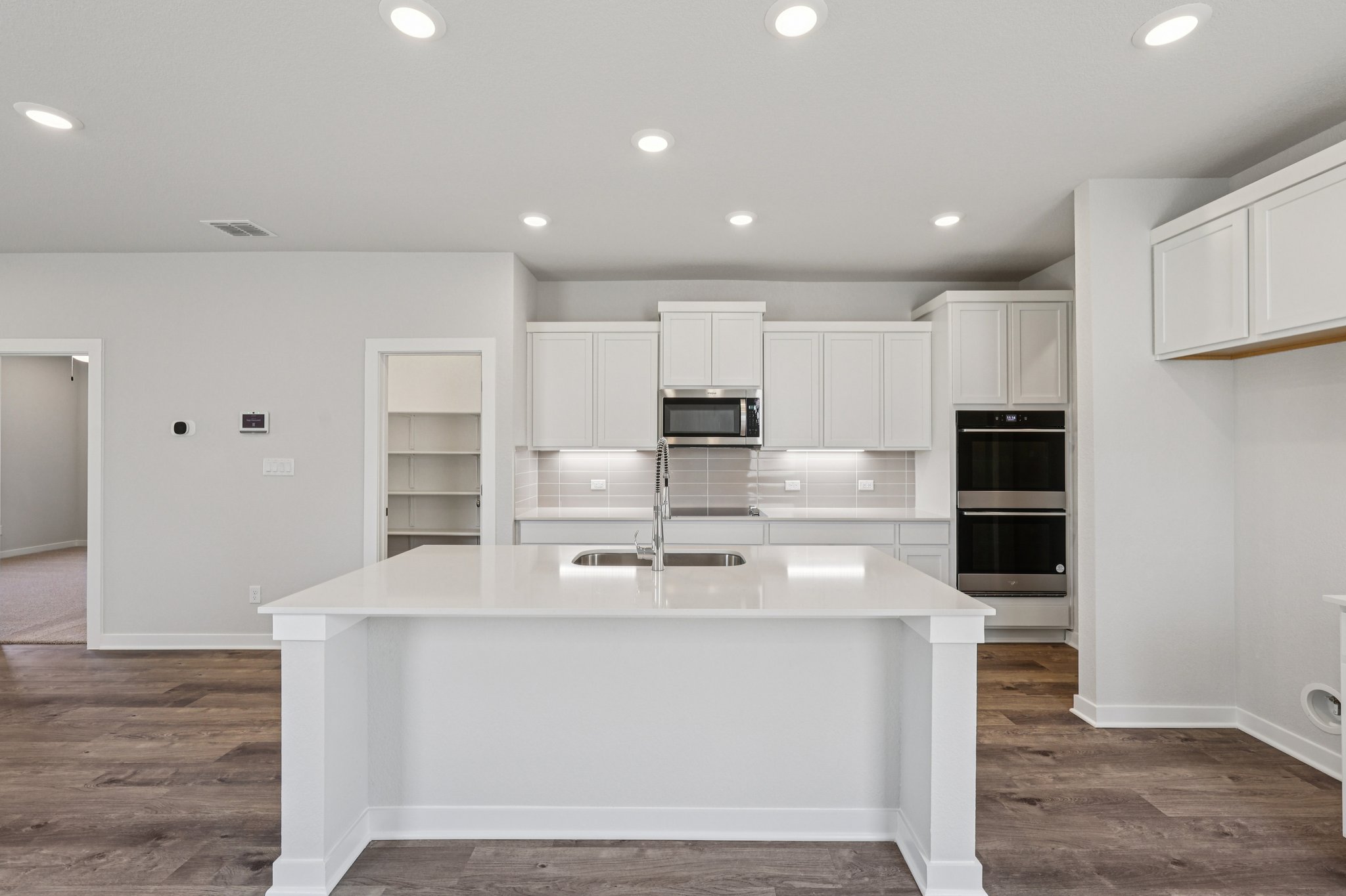 A kitchen with white cabinets.
