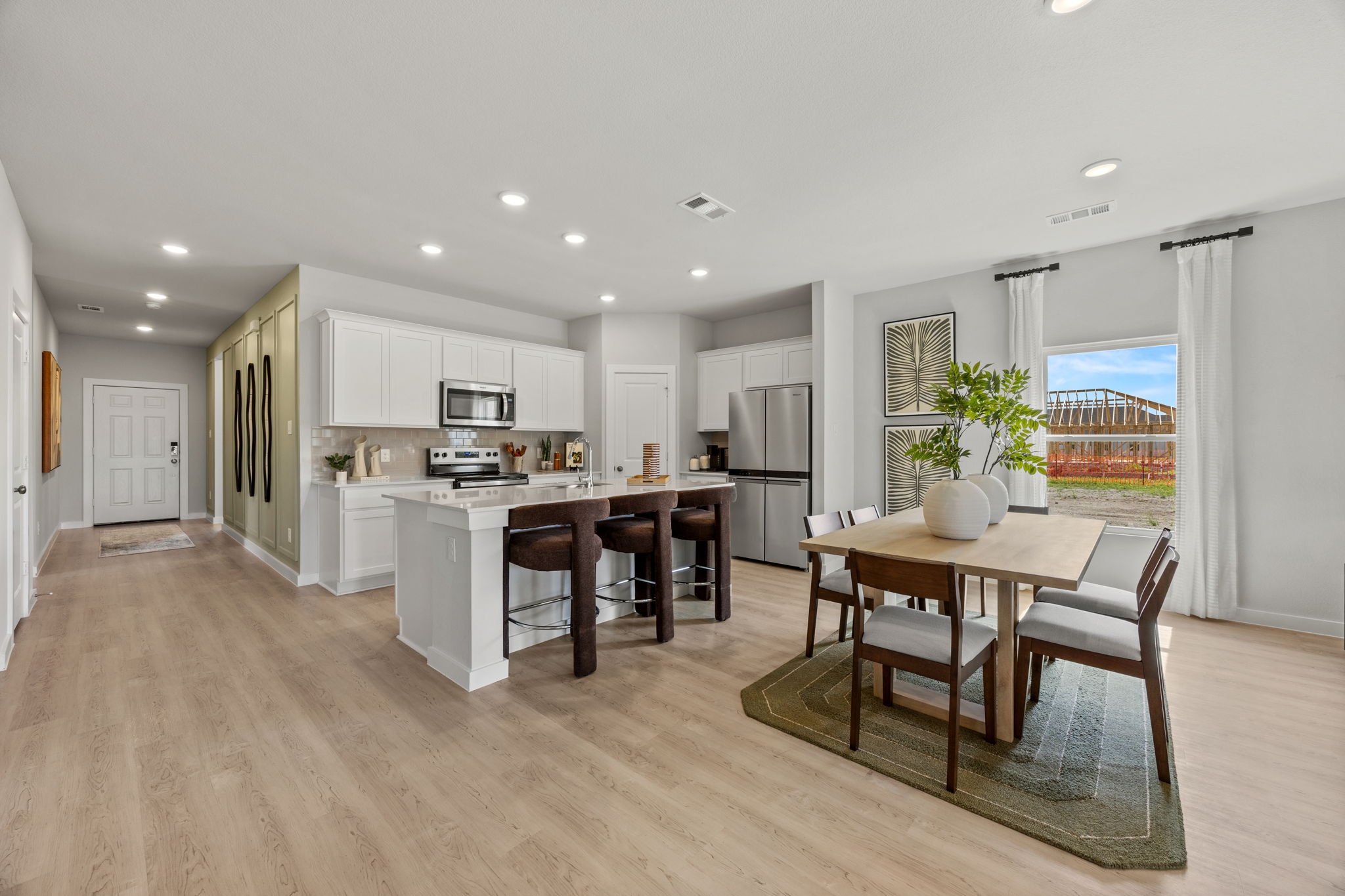 A kitchen with a dining table and chairs.