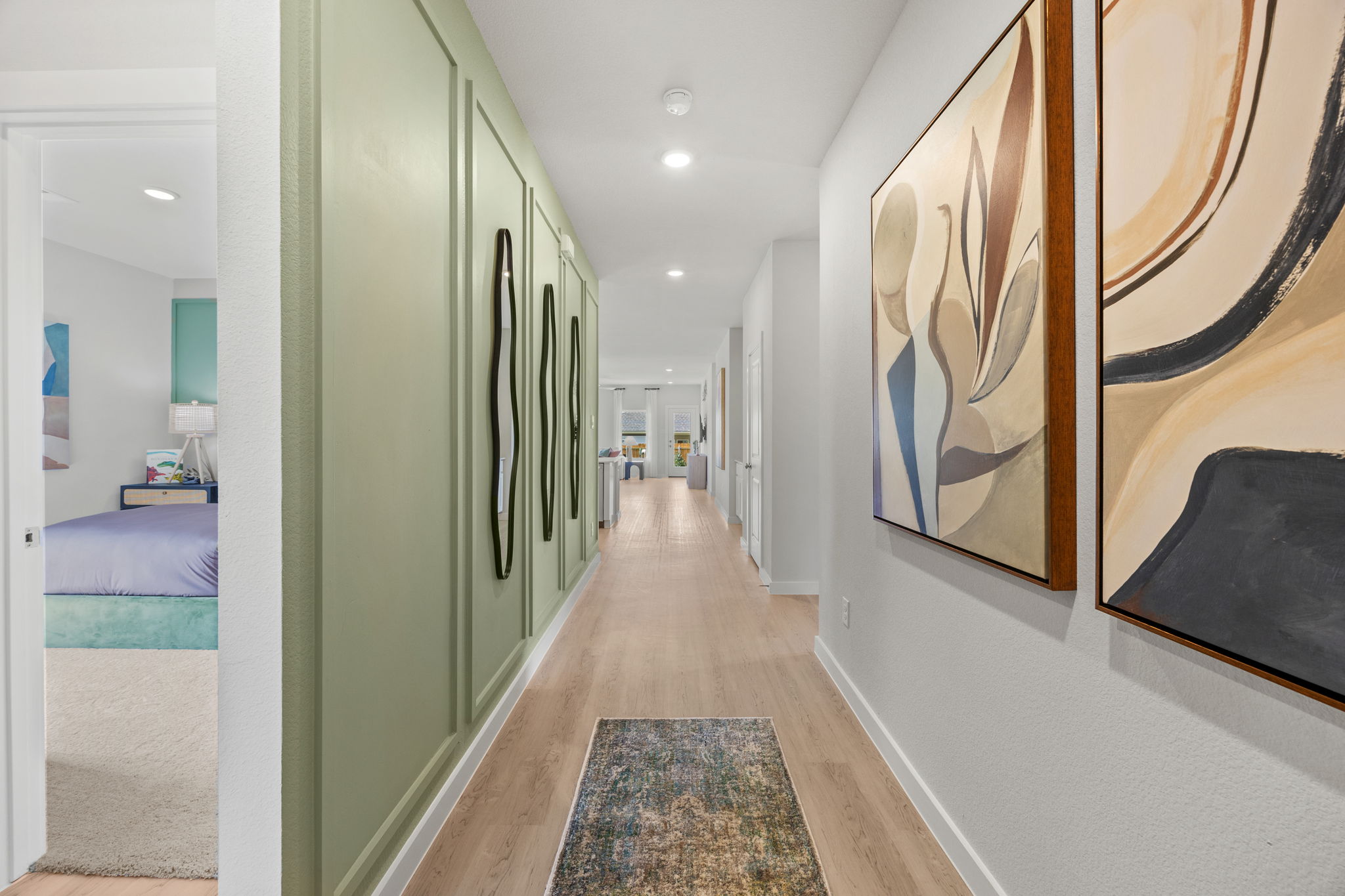 A hallway with a bed and a rug.