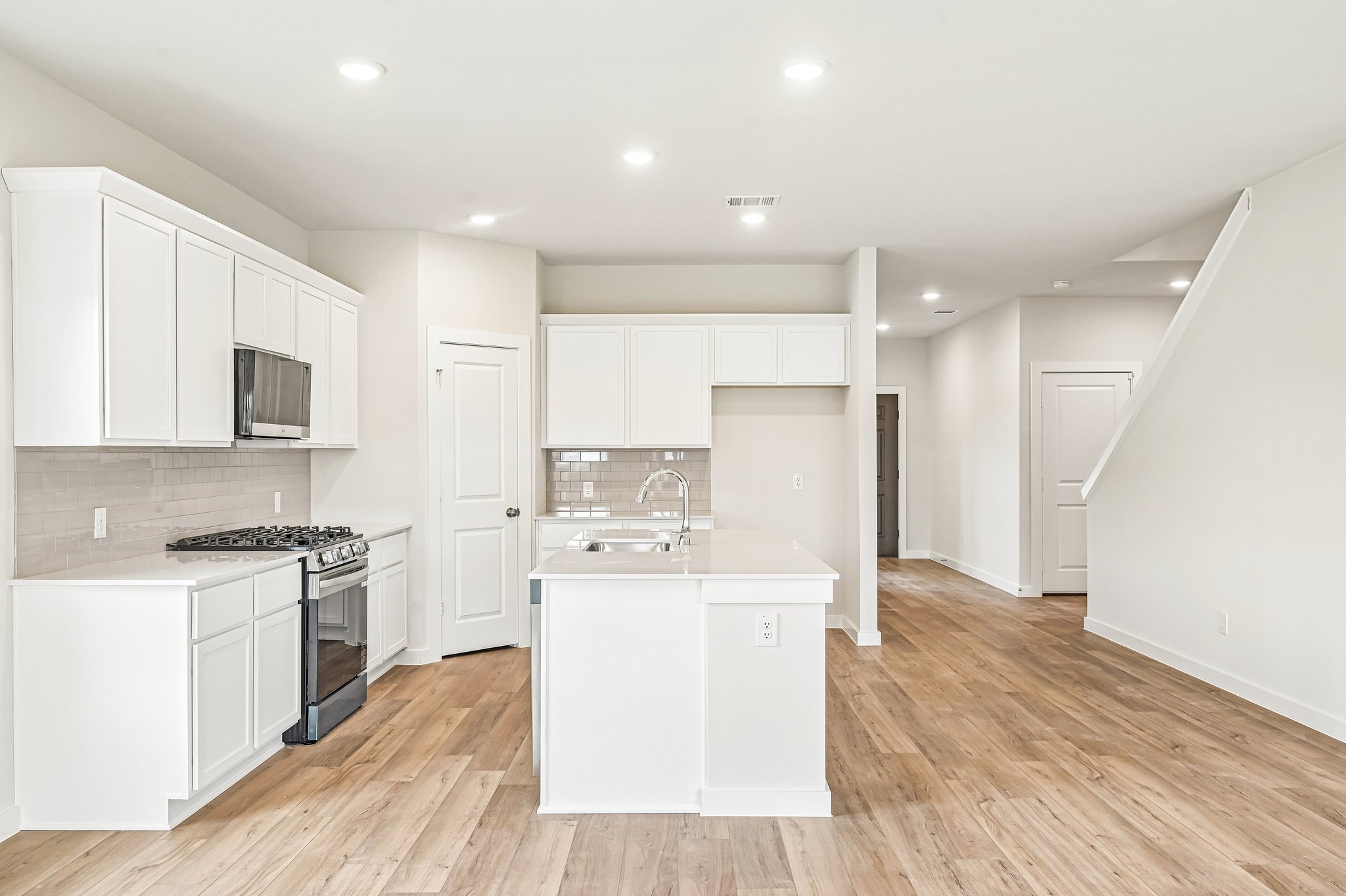 A kitchen with white cabinets.