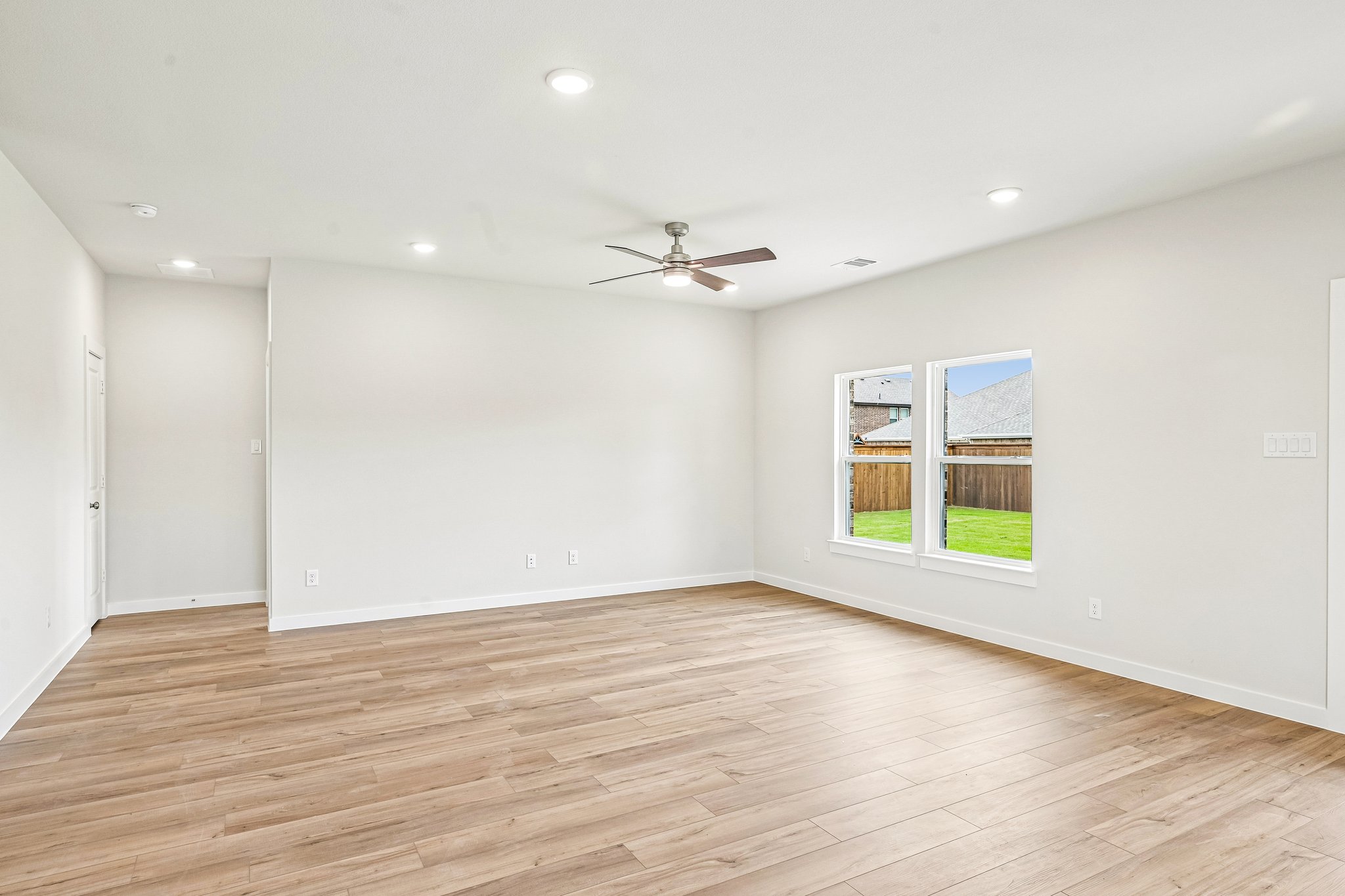 A room with a wood floor and a ceiling fan.