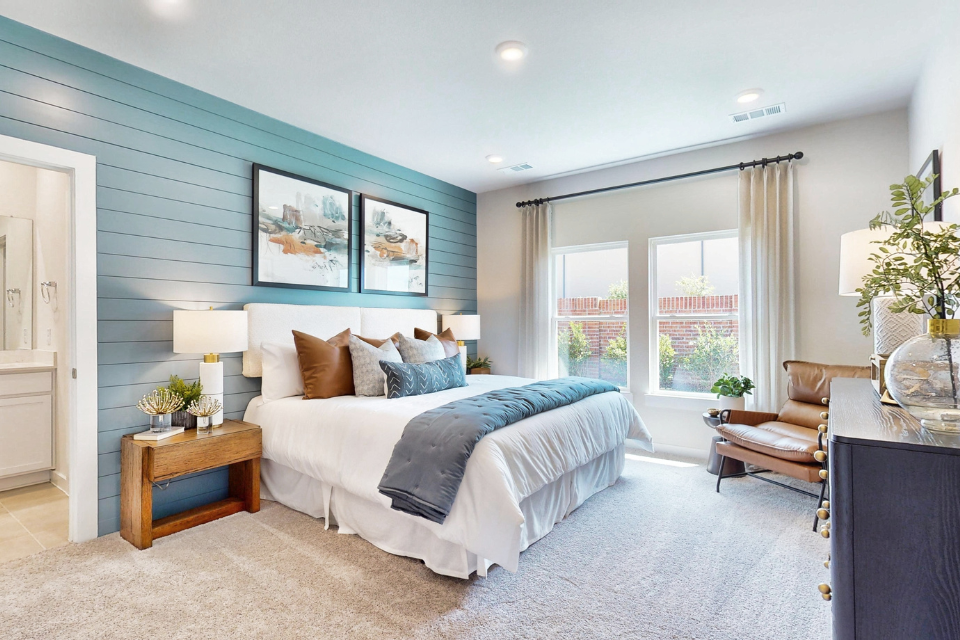 A bedroom with a bed and a chair.