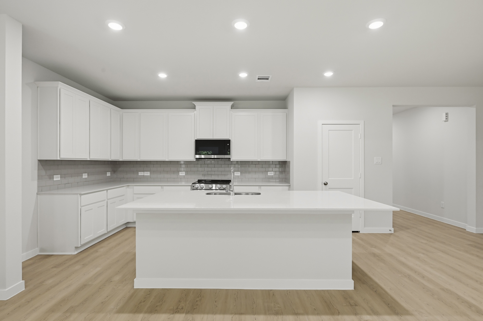 A kitchen with white cabinets.