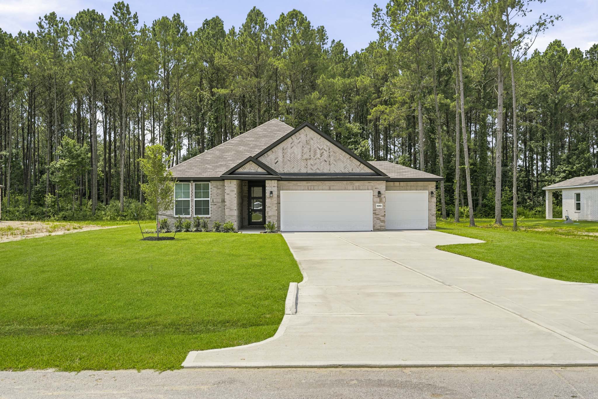 A house with a garage and trees in the background.