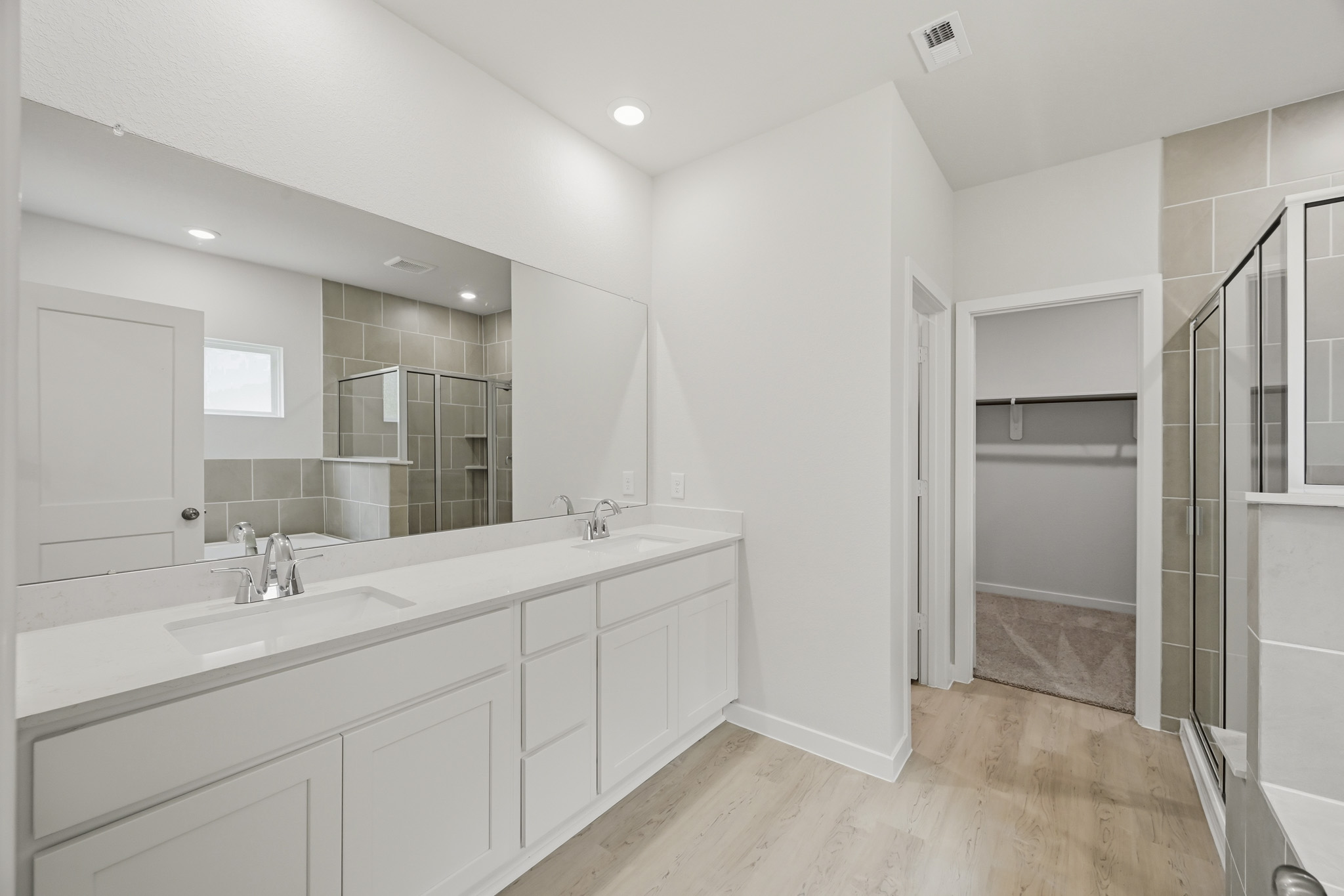 A bathroom with white cabinets.