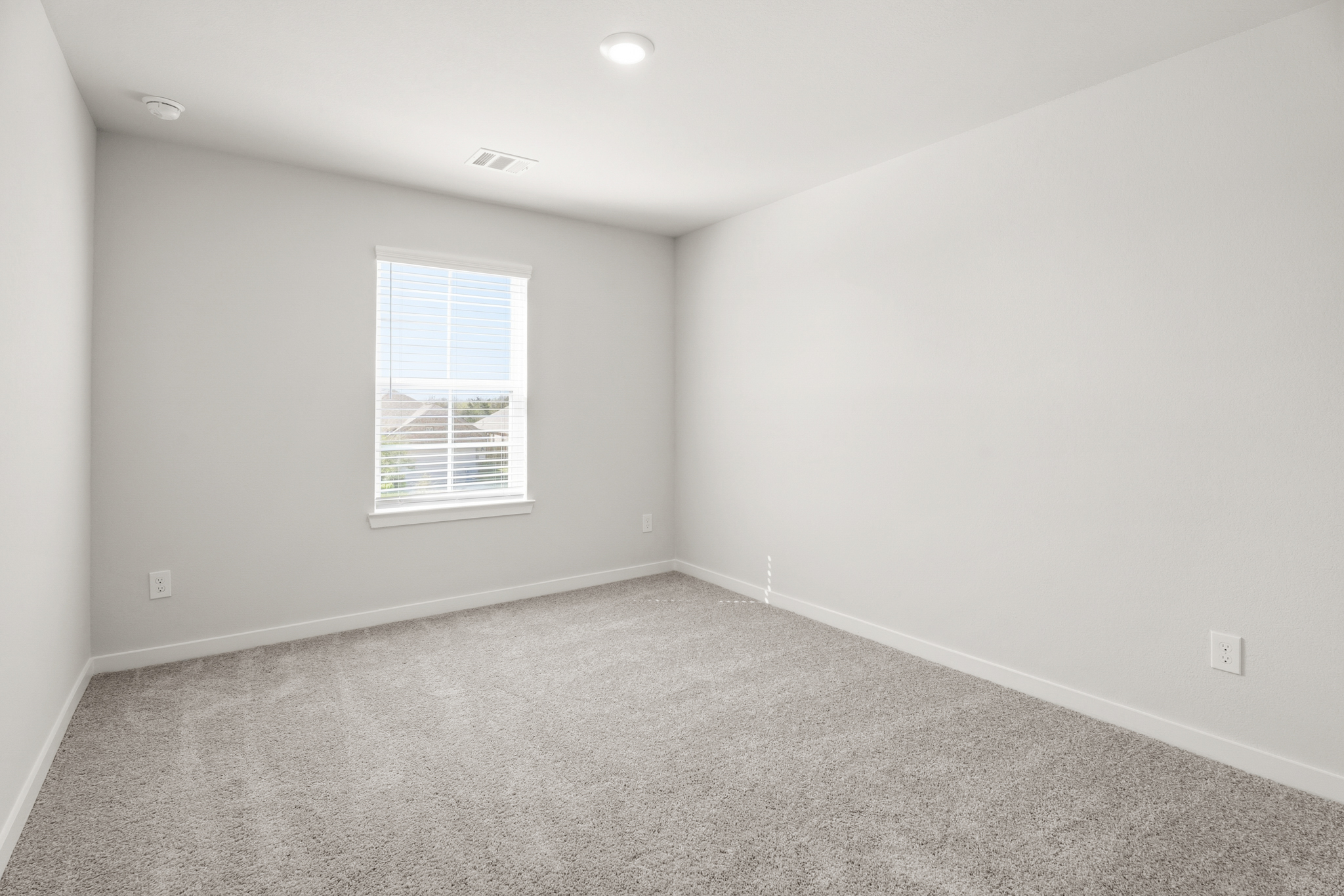 A room with a window and carpet.