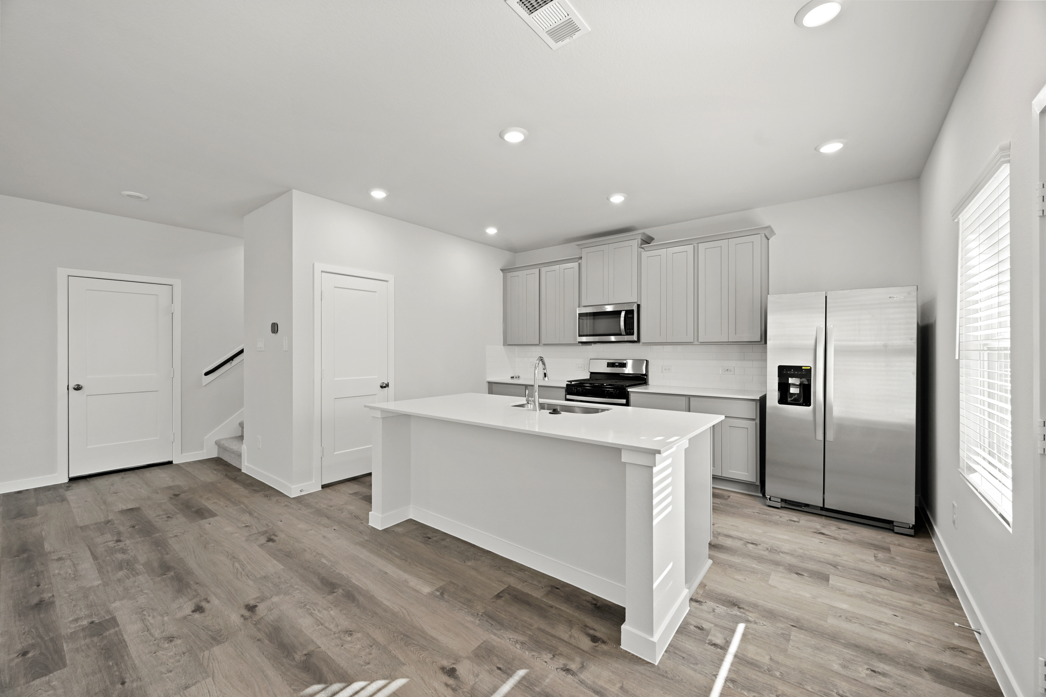 A kitchen with white cabinets.