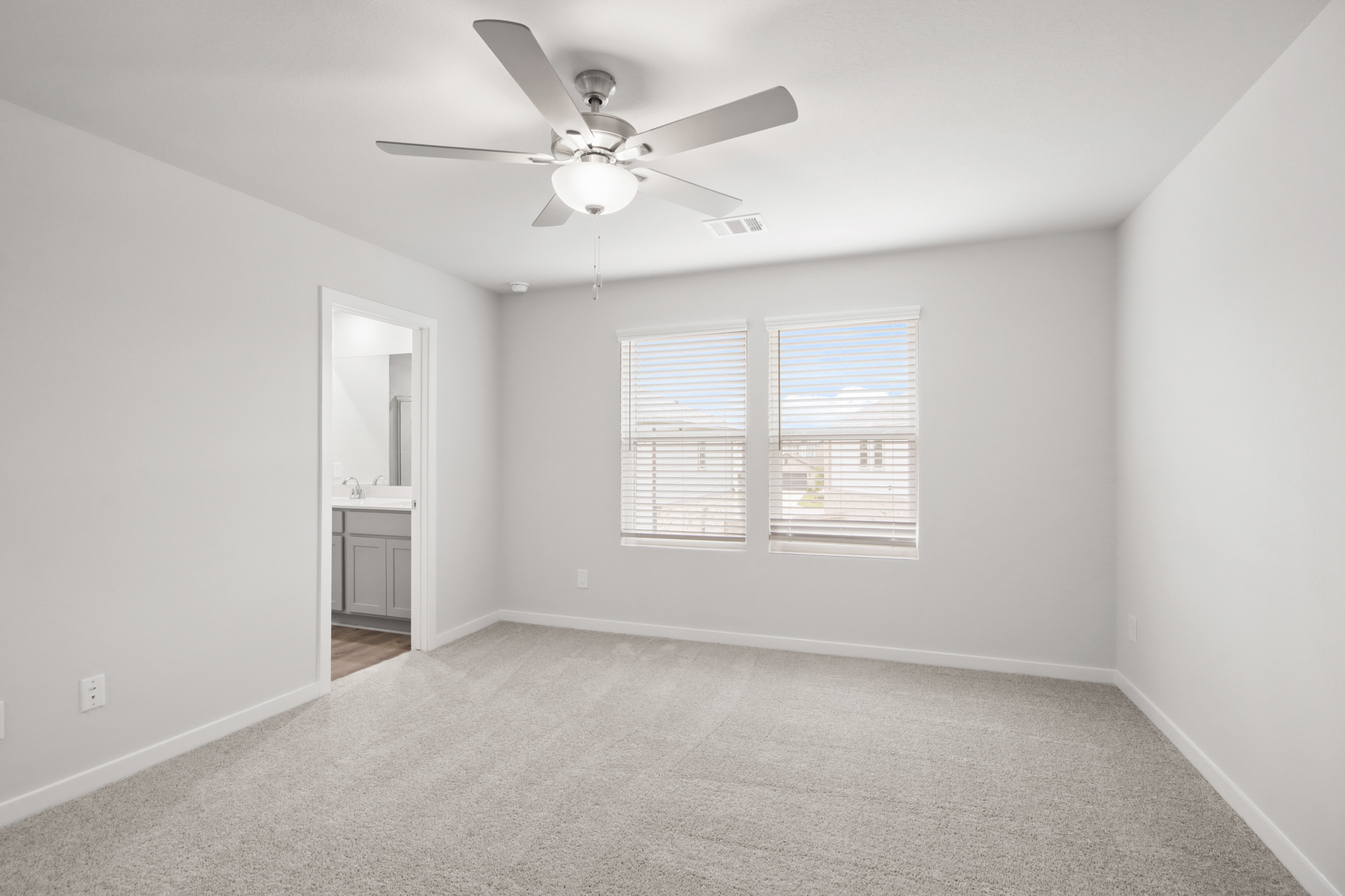 A room with a ceiling fan and a window.
