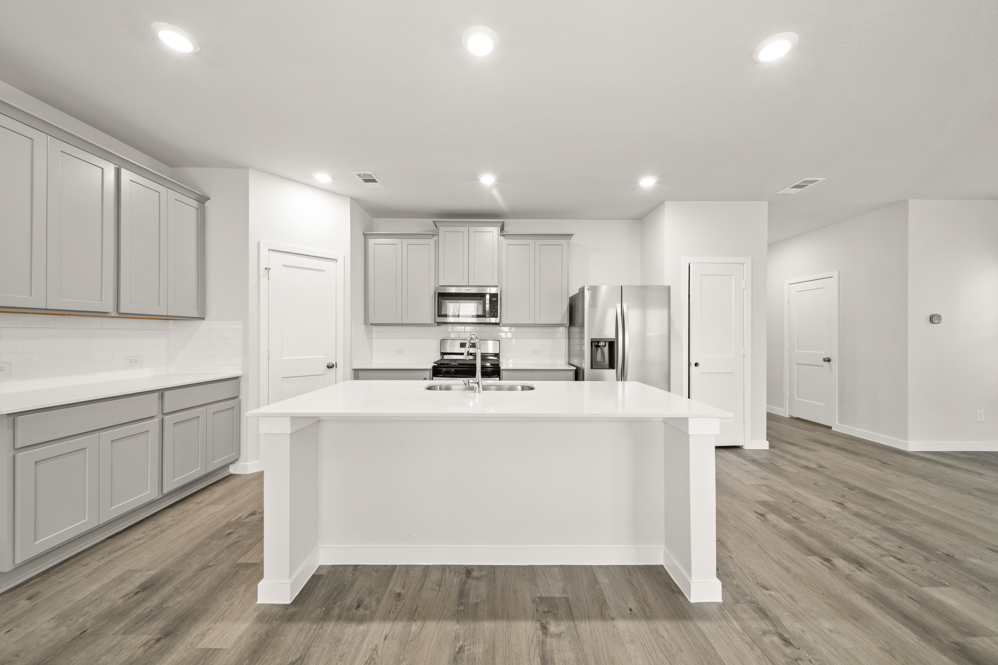 A kitchen with white cabinets.