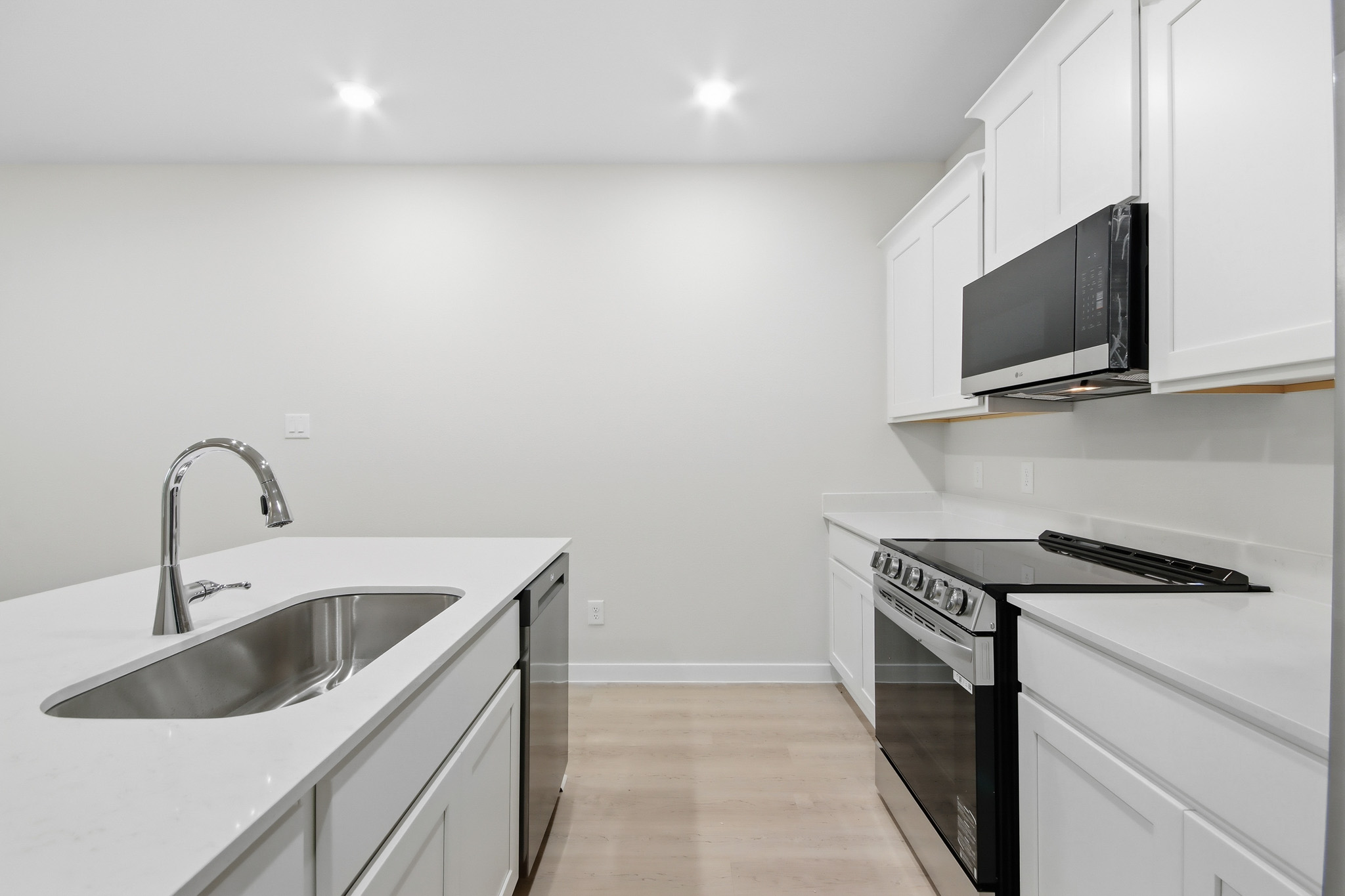 A kitchen with white cabinets.