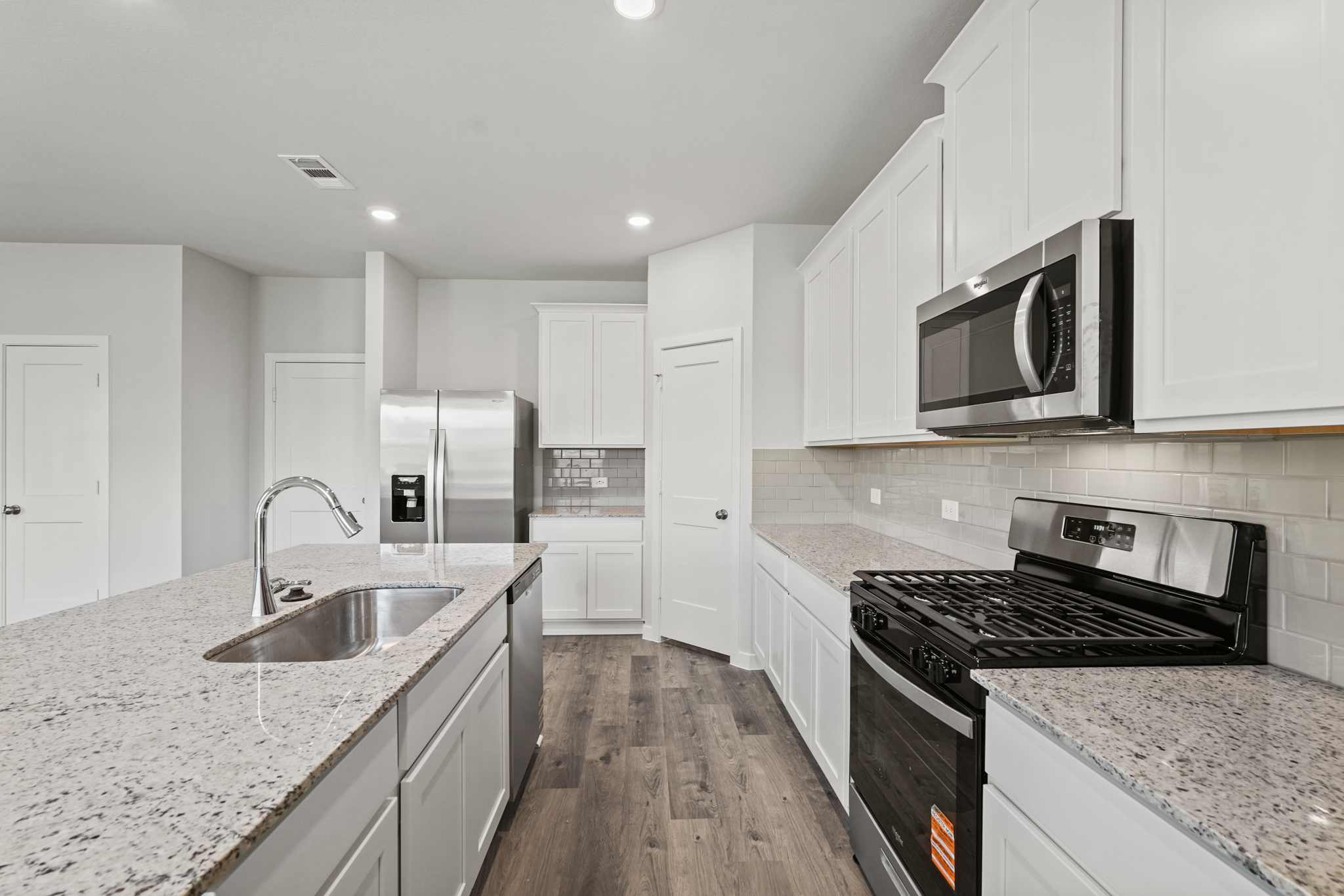 A kitchen with white cabinets.