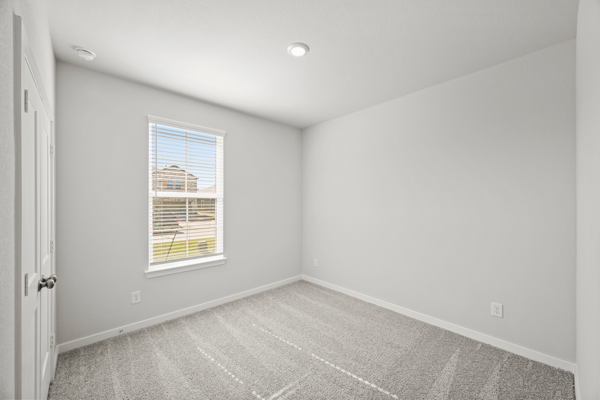 A room with a window and a rug.