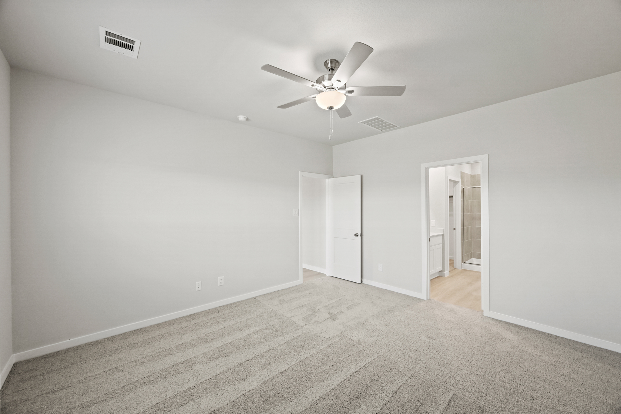 A room with a ceiling fan and a door.