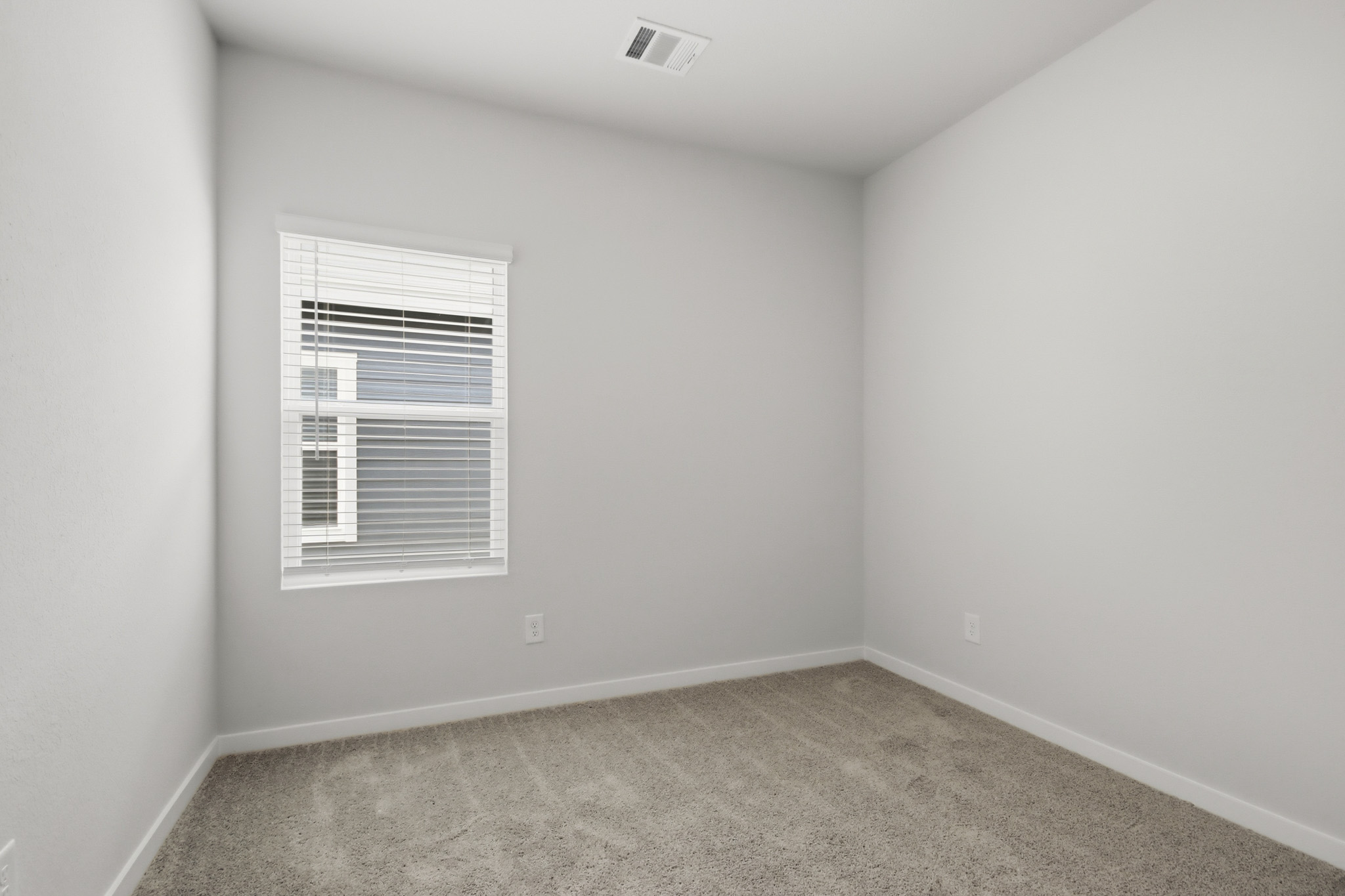 A room with a window and a carpet.