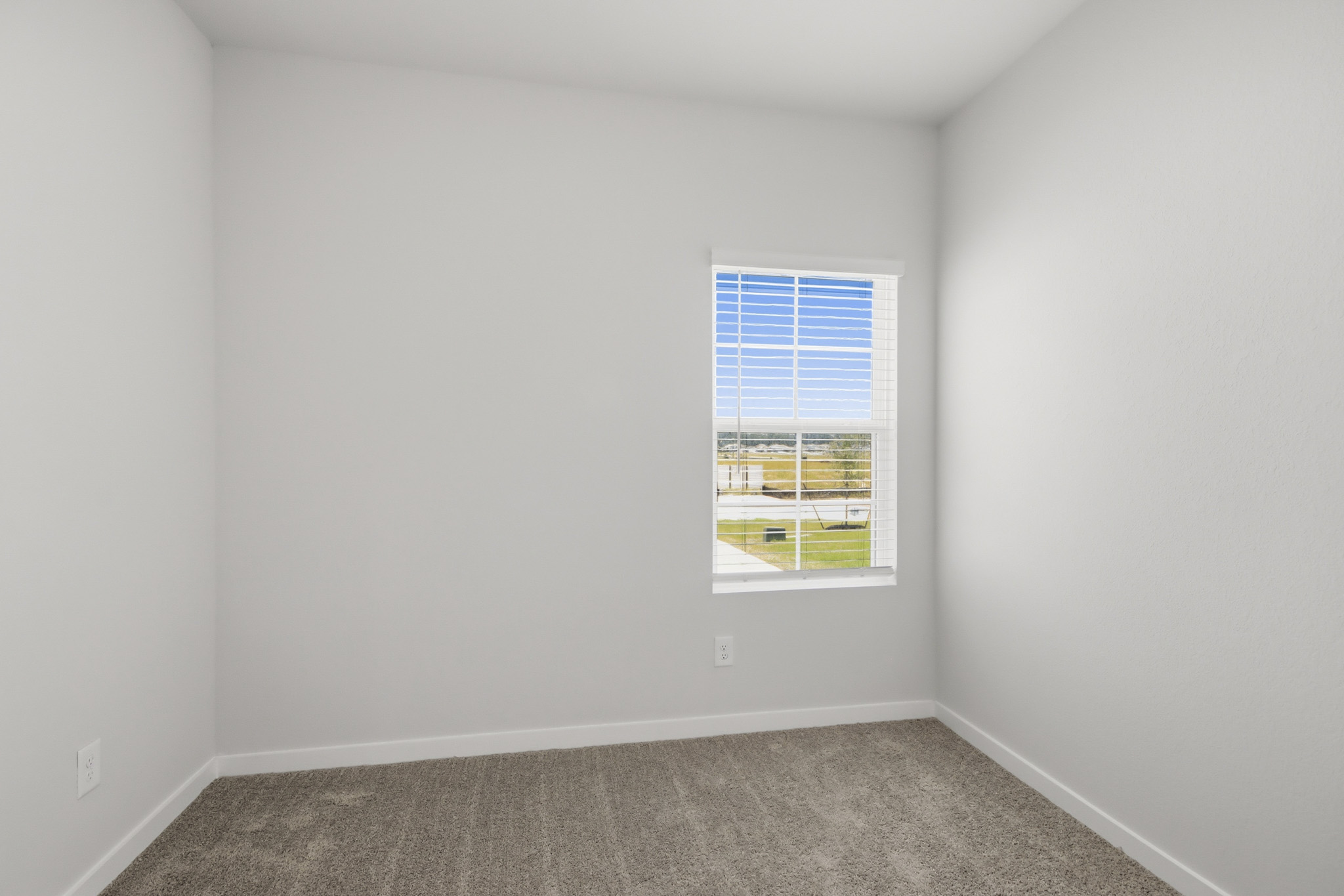 A room with a window and a carpet.