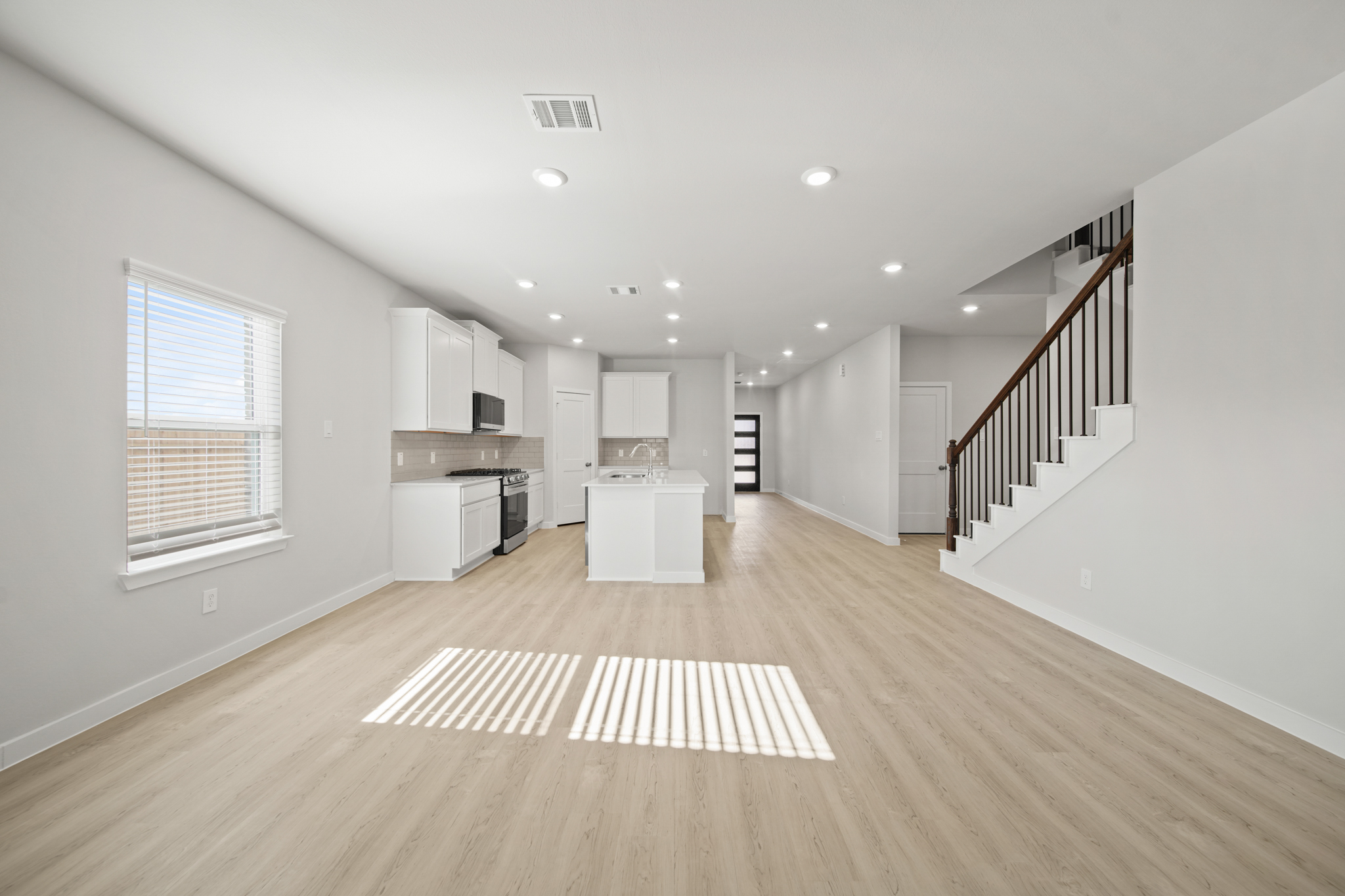 A large empty room with a wood floor and white walls.
