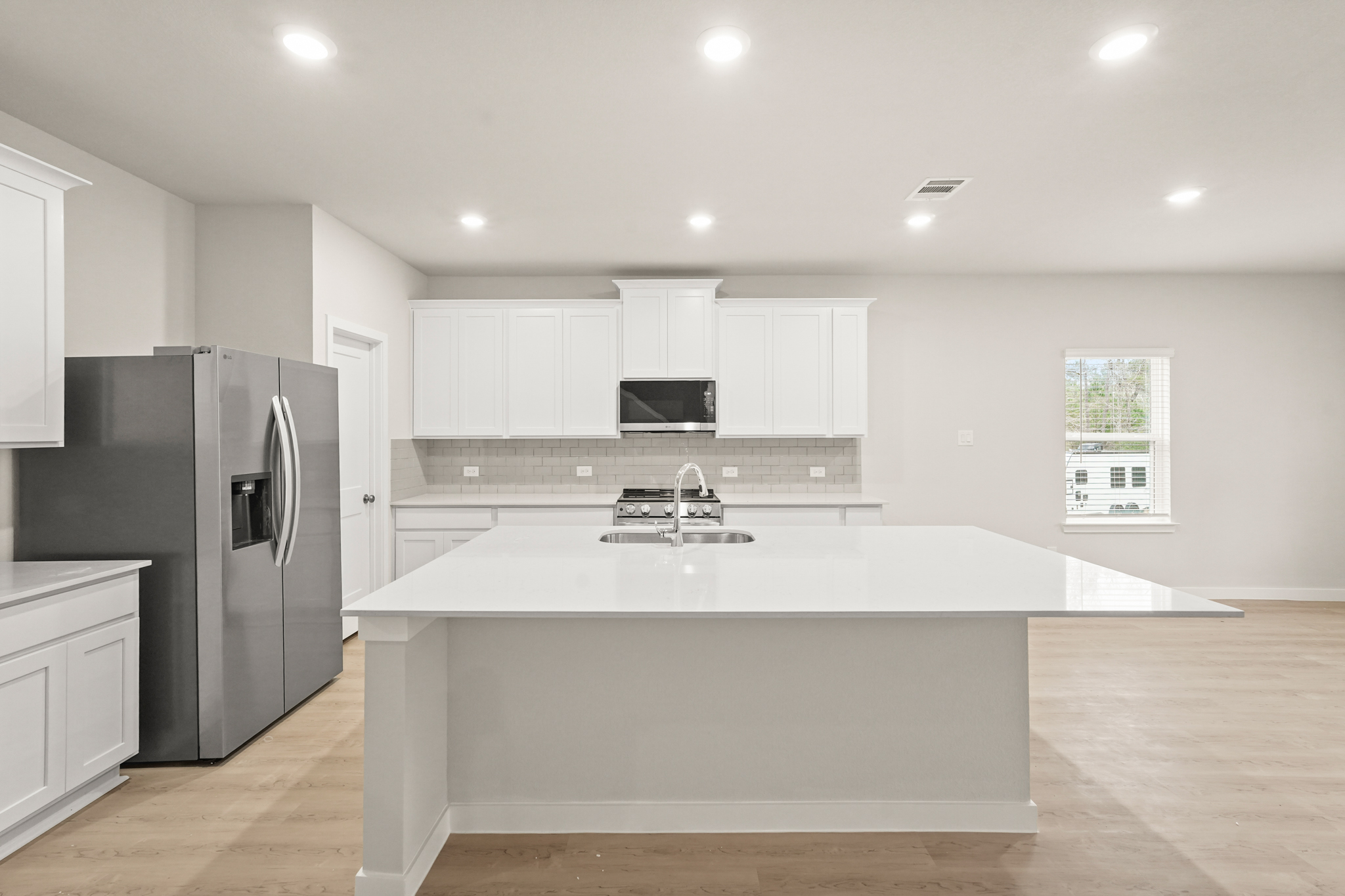 A kitchen with white cabinets.