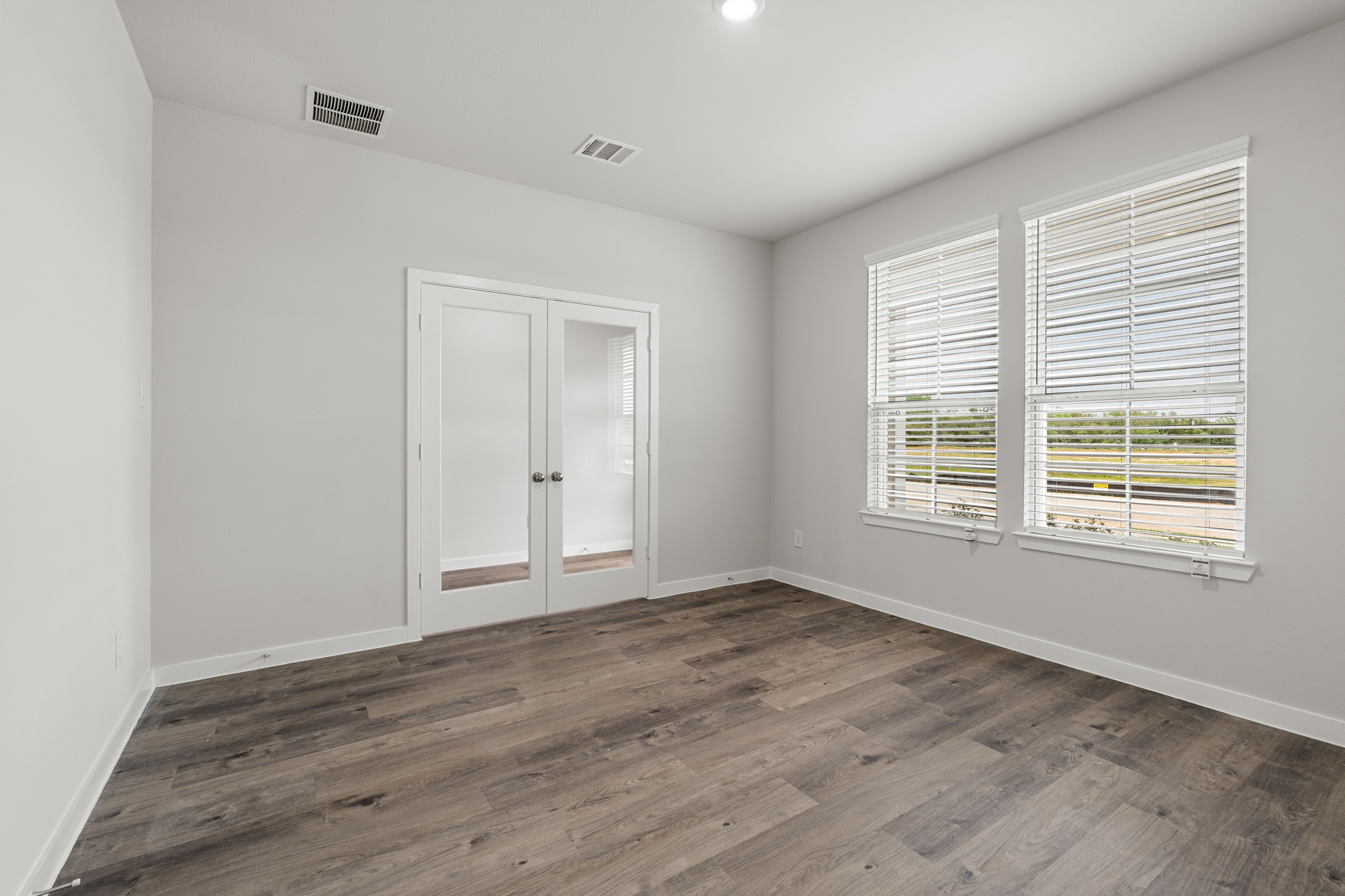 A room with a wood floor and a window.