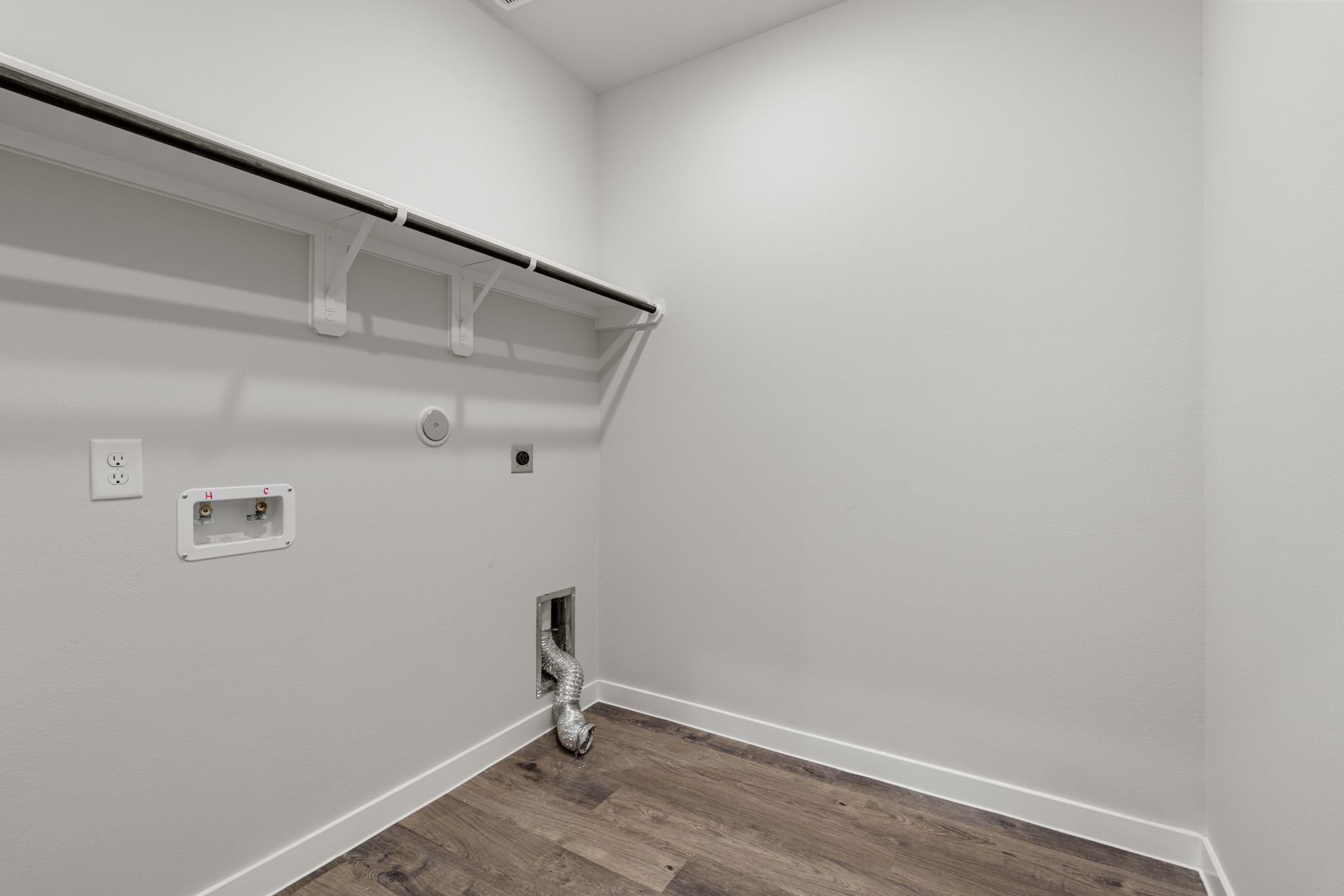 A white room with a wood floor.