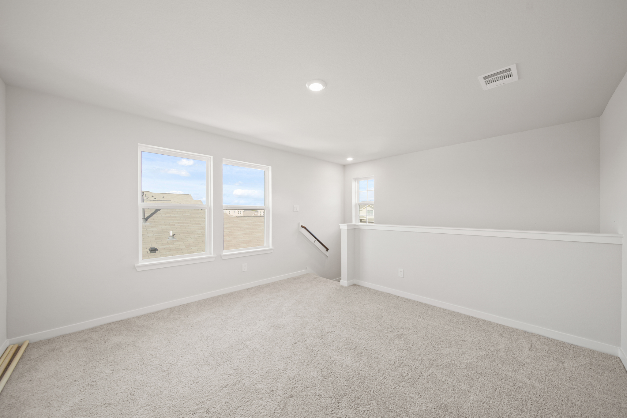 A room with a white wall and a window.